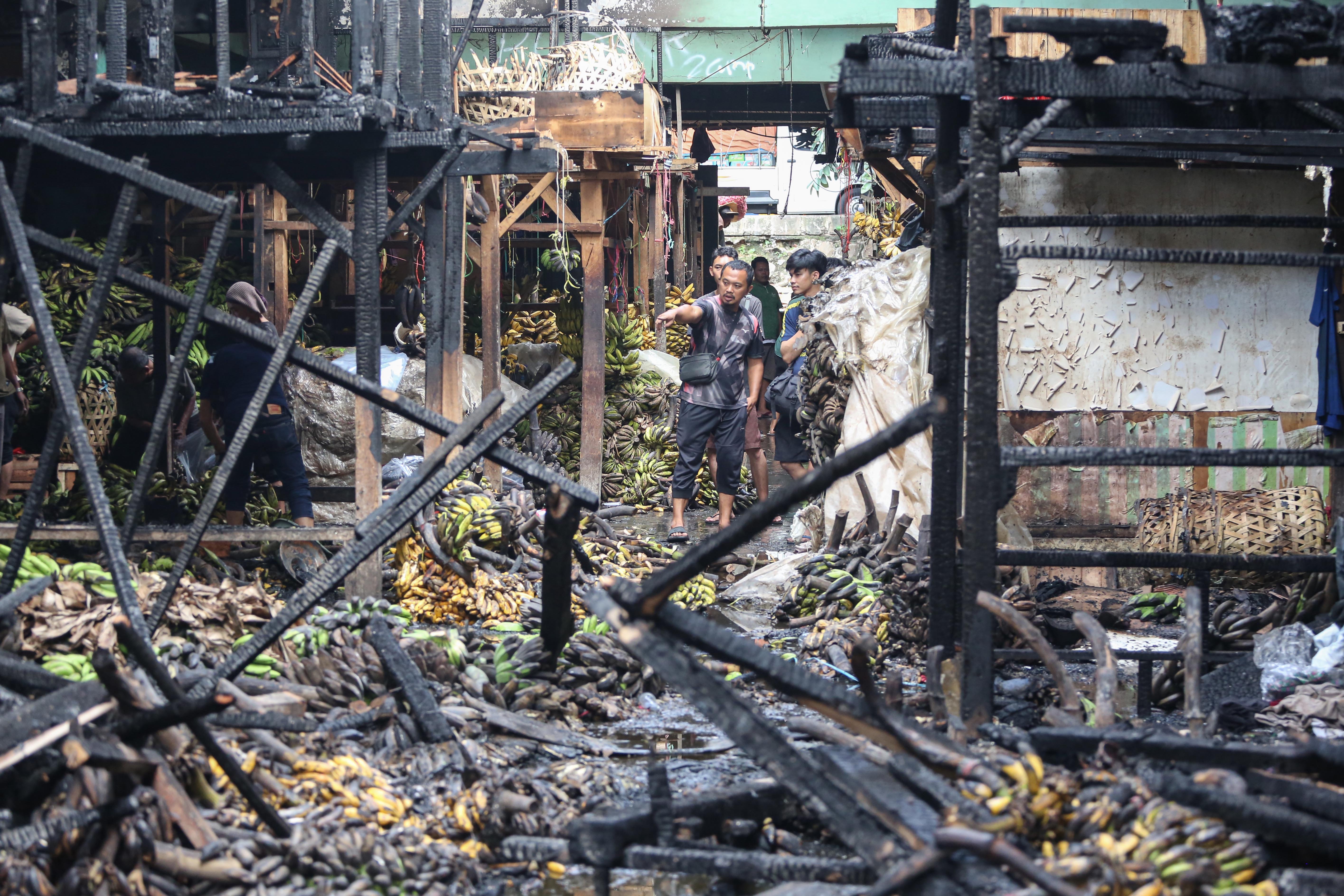 Pedagang melihat kios tempat berjualannya usai terbakar di Pasar Induk Kramat Jati, Jakarta Timur, Senin (15/12/2025). Kebakaran yang diduga akibat korsleting listrik tersebut menyebabkan 350 kios pedagang hangus terbakar dengan kerugian mencapai Rp10 miliar.