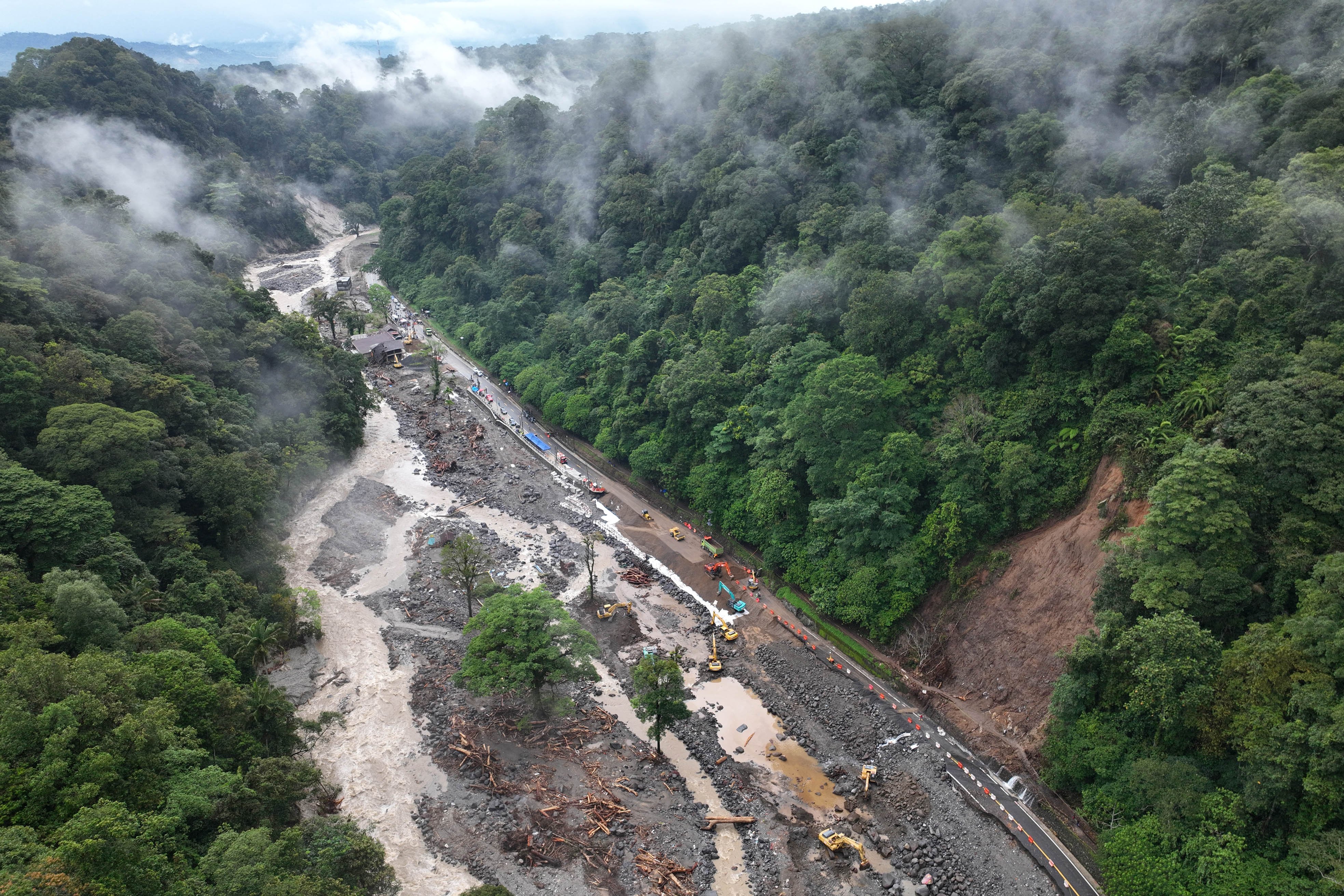 Foto udara puluhan alat berat bekerja membersihkan sisa longsor pemulihan akses jalan nasional di Lembah Anai, Sumatera Barat, Minggu (7/12/2025). Banjir bandang dan longsor yang menerjang jalan nasional itu pada Kamis (27/11) membuat akses jalan dari arah kota Padang terputus total.