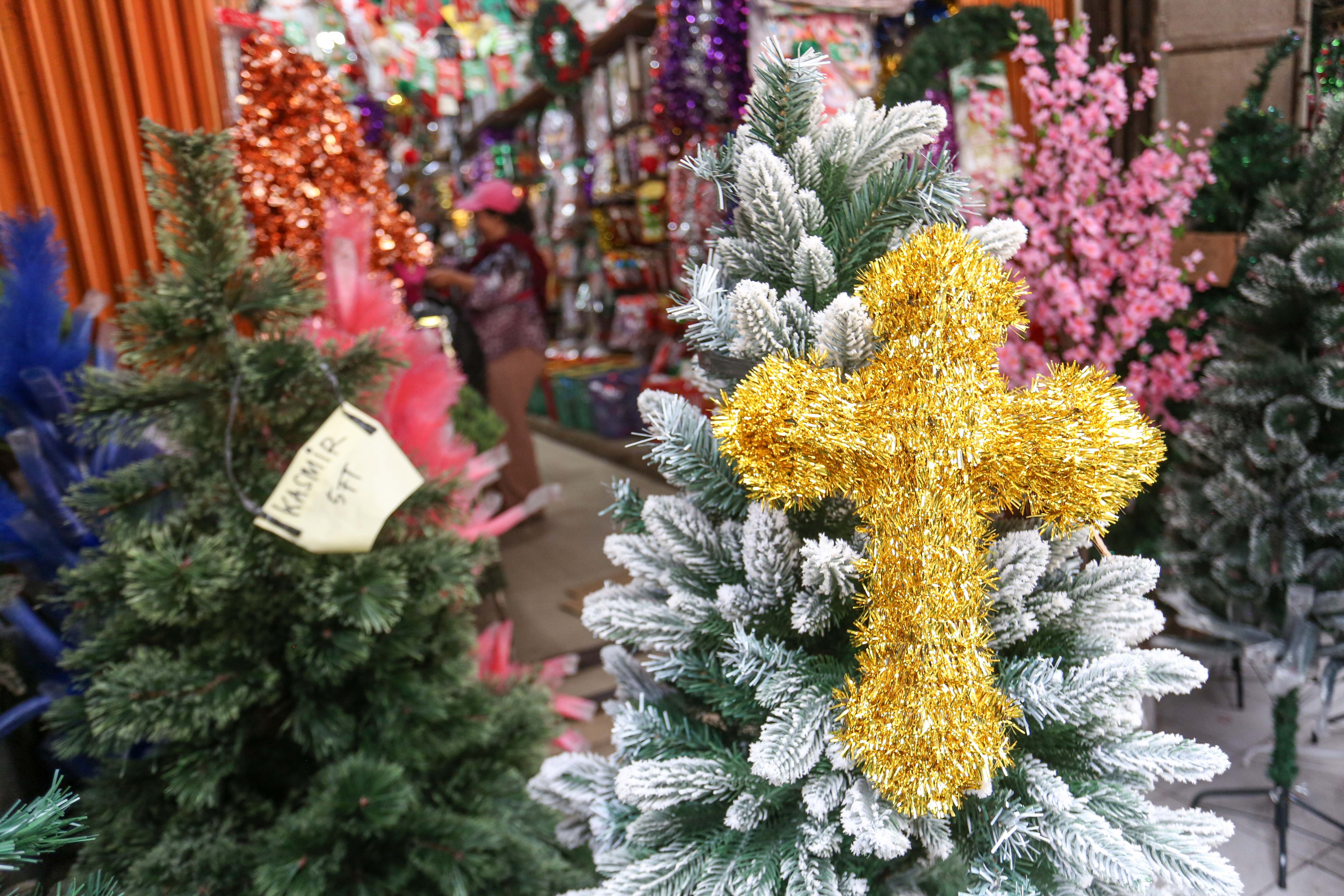 Calon pembeli melihat hiasan Natal yang dijual di salah satu toko di Pasar Asemka, Jakarta Barat, Senin (22/12/2025). Dekorasi bertemakan Natal seperti lonceng, pita, lampu bintang, topi, pohon Natal hingga hiasan figur rusa, boneka salju dan sinterklas tersebut dijual dengan harga mulai dari Rp.5.000 hingga Rp10 juta per buah.
