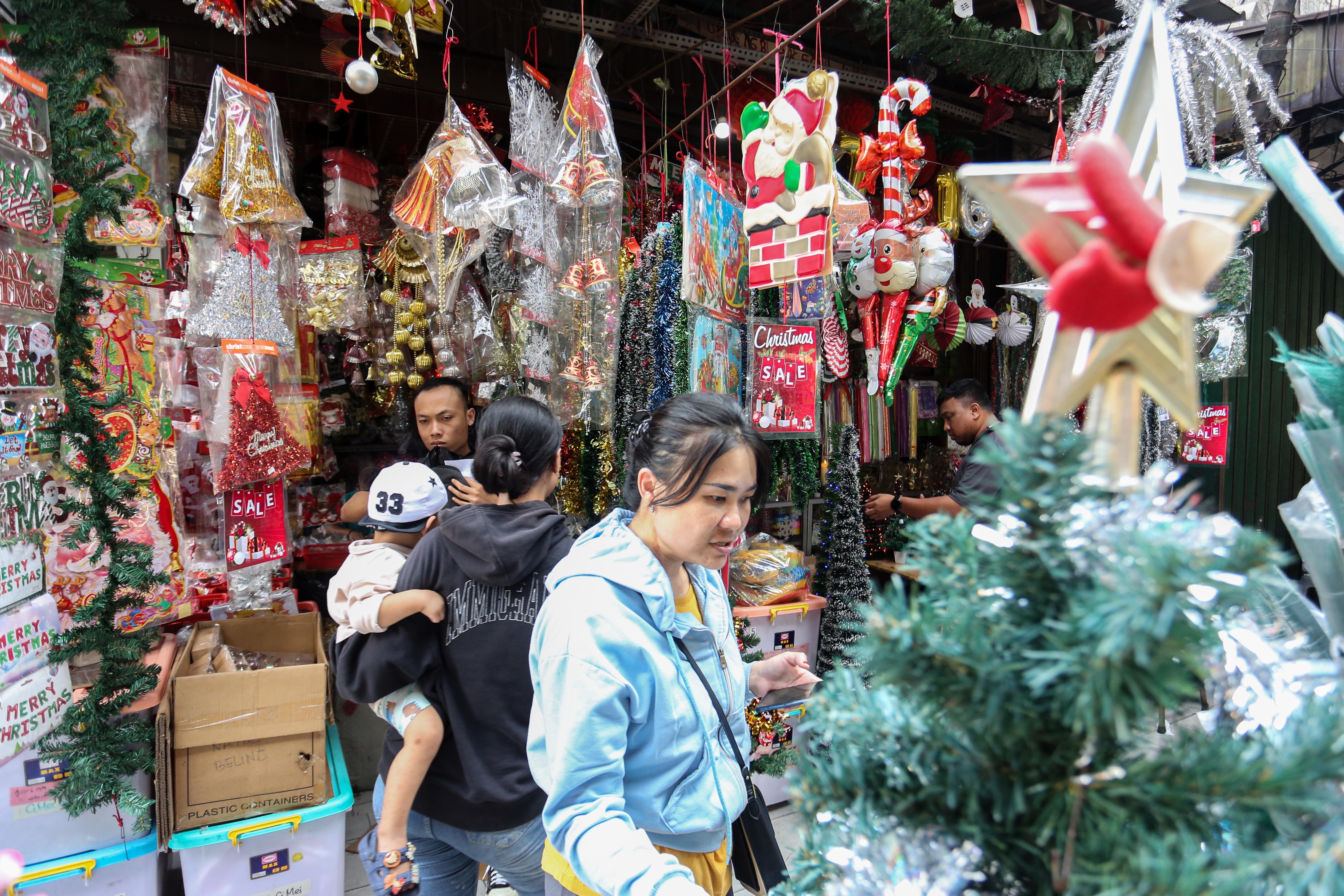 Calon pembeli melihat hiasan Natal yang dijual di salah satu toko di Pasar Asemka, Jakarta Barat, Senin (22/12/2025). Dekorasi bertemakan Natal seperti lonceng, pita, lampu bintang, topi, pohon Natal hingga hiasan figur rusa, boneka salju dan sinterklas tersebut dijual dengan harga mulai dari Rp.5.000 hingga Rp10 juta per buah.