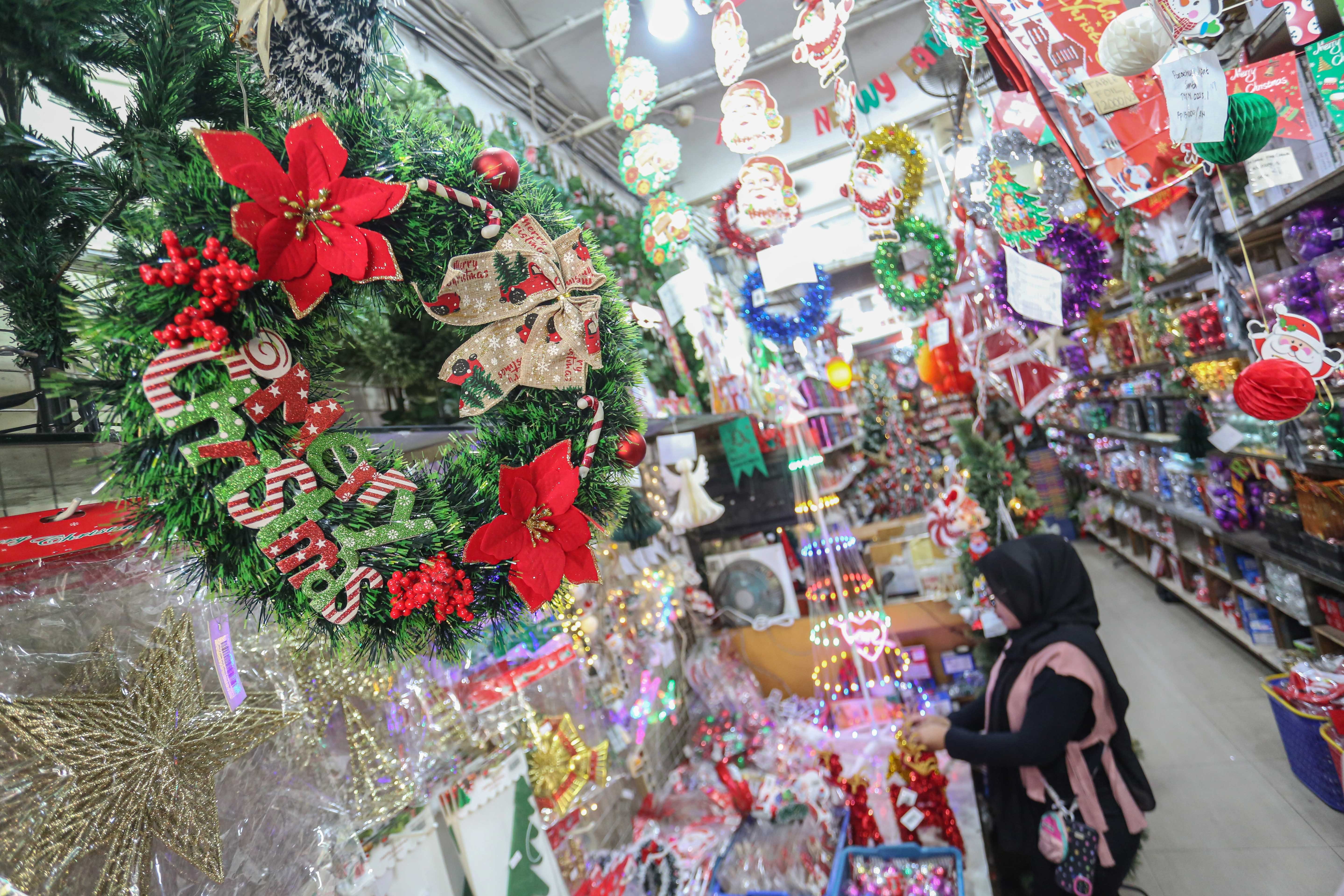 Pedagang menata hiasan Natal yang dijual di salah satu toko di Pasar Asemka, Jakarta Barat, Senin (22/12/2025). Dekorasi bertemakan Natal seperti lonceng, pita, lampu bintang, topi, pohon Natal hingga hiasan figur rusa, boneka salju dan sinterklas tersebut dijual dengan harga mulai dari Rp.5.000 hingga Rp10 juta per buah.