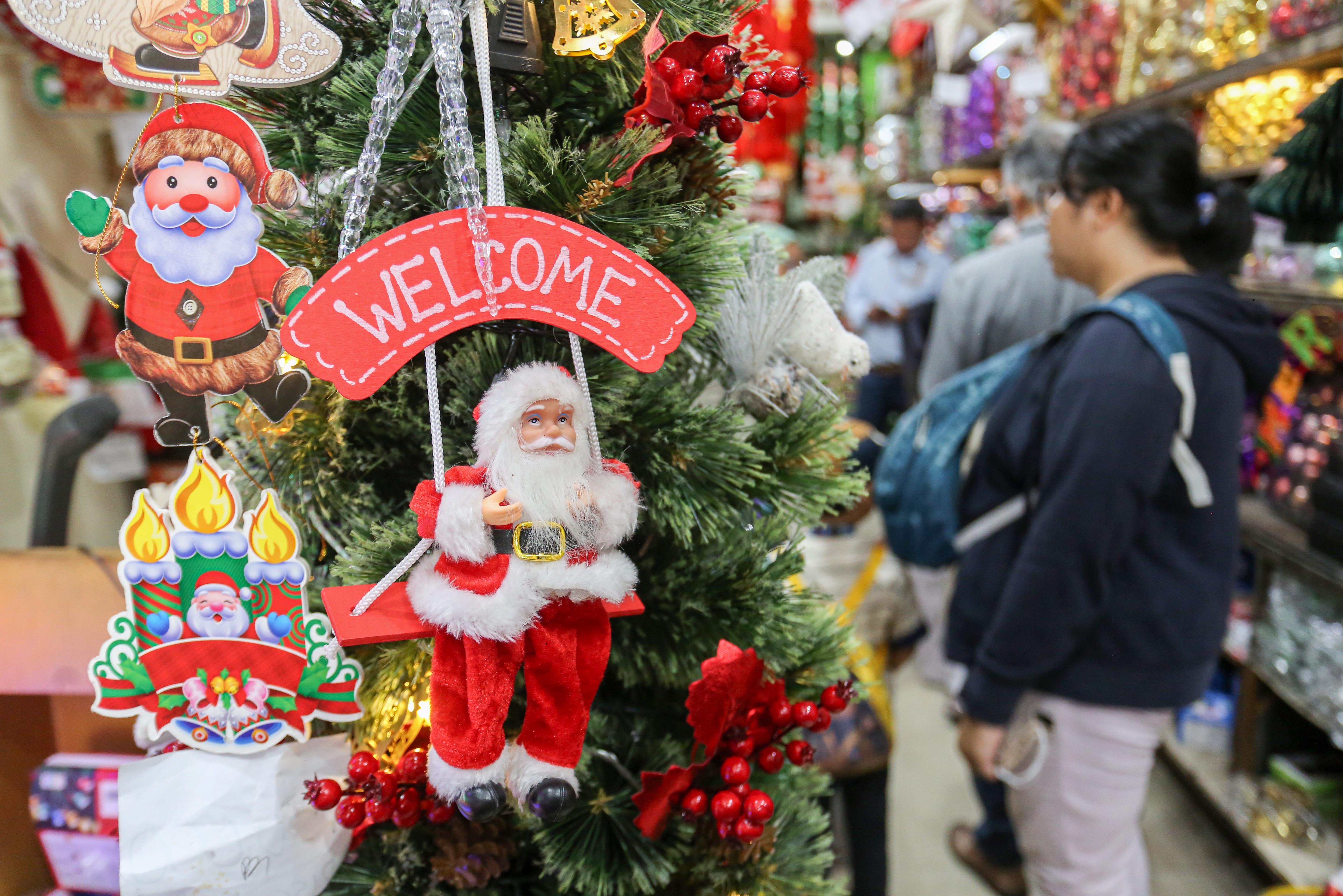 Calon pembeli melihat hiasan Natal yang dijual di salah satu toko di Pasar Asemka, Jakarta Barat, Senin (22/12/2025). Dekorasi bertemakan Natal seperti lonceng, pita, lampu bintang, topi, pohon Natal hingga hiasan figur rusa, boneka salju dan sinterklas tersebut dijual dengan harga mulai dari Rp.5.000 hingga Rp10 juta per buah.