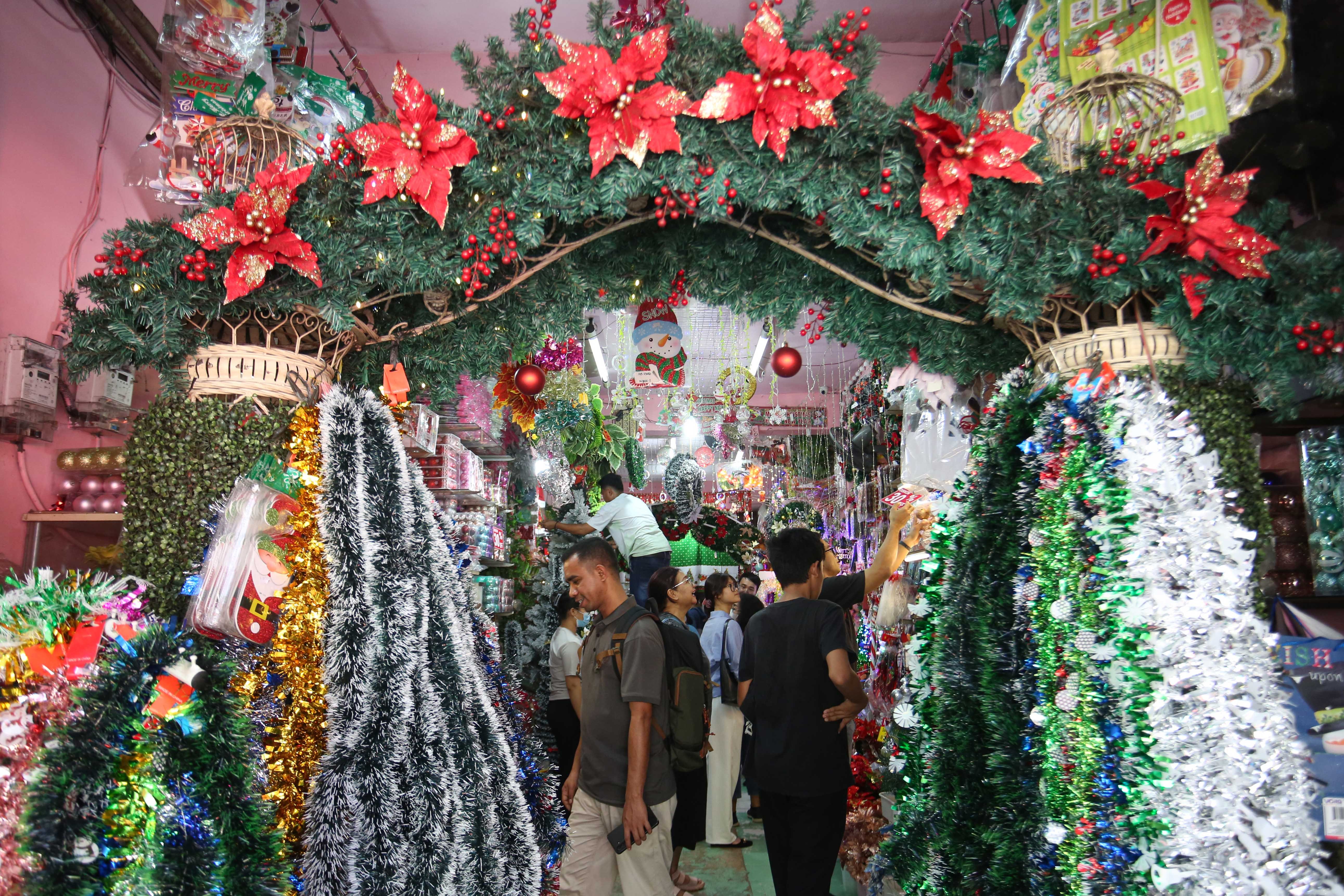 Calon pembeli melihat hiasan Natal yang dijual di salah satu toko di Pasar Asemka, Jakarta Barat, Senin (22/12/2025). Dekorasi bertemakan Natal seperti lonceng, pita, lampu bintang, topi, pohon Natal hingga hiasan figur rusa, boneka salju dan sinterklas tersebut dijual dengan harga mulai dari Rp.5.000 hingga Rp10 juta per buah.