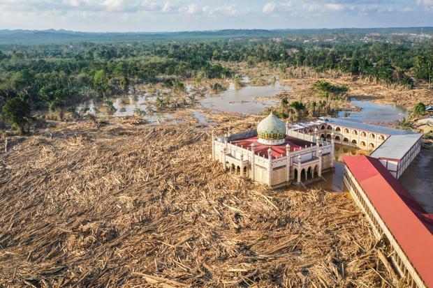 Foto udara menampilkan tumpukan kayu-kayu memenuhi area Pondok Pesantren Darul Mukhlishin pascabanjir bandang di Desa Tanjung Karang, Karang Baru, Kabupaten Aceh Tamiang, Aceh, Jumat (5/12/2025). Usai sepekan setelah bencana banjir bandang, akses menuju Desa Tanjung Karang masih terhambat akibat banyaknya tumpukan pohon dan lumpur tebal dari Sungai Tamiang sehingga bantuan sulit masuk ke wilayah tersebut.