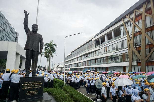 Buruh dan karyawan keluar pabrik melintas di samping patung pendiri Sritex HM. Lukminto di Pabrik Sri Rejeki Isman Tbk (Sritex) di Sukoharjo, Jawa Tengah, Jumat (28/2/2025). Dinas Tenaga Kerja dan Transmigrasi (Disnakertrans) Jawa Tengah mencatat 10.965 buruh dan karyawan di empat perusahaan terdampak Pemutusan Hubungan Kerja (PHK) PT. Sritex Tbk setelah diputus pailit oleh Pengadilan Niaga.