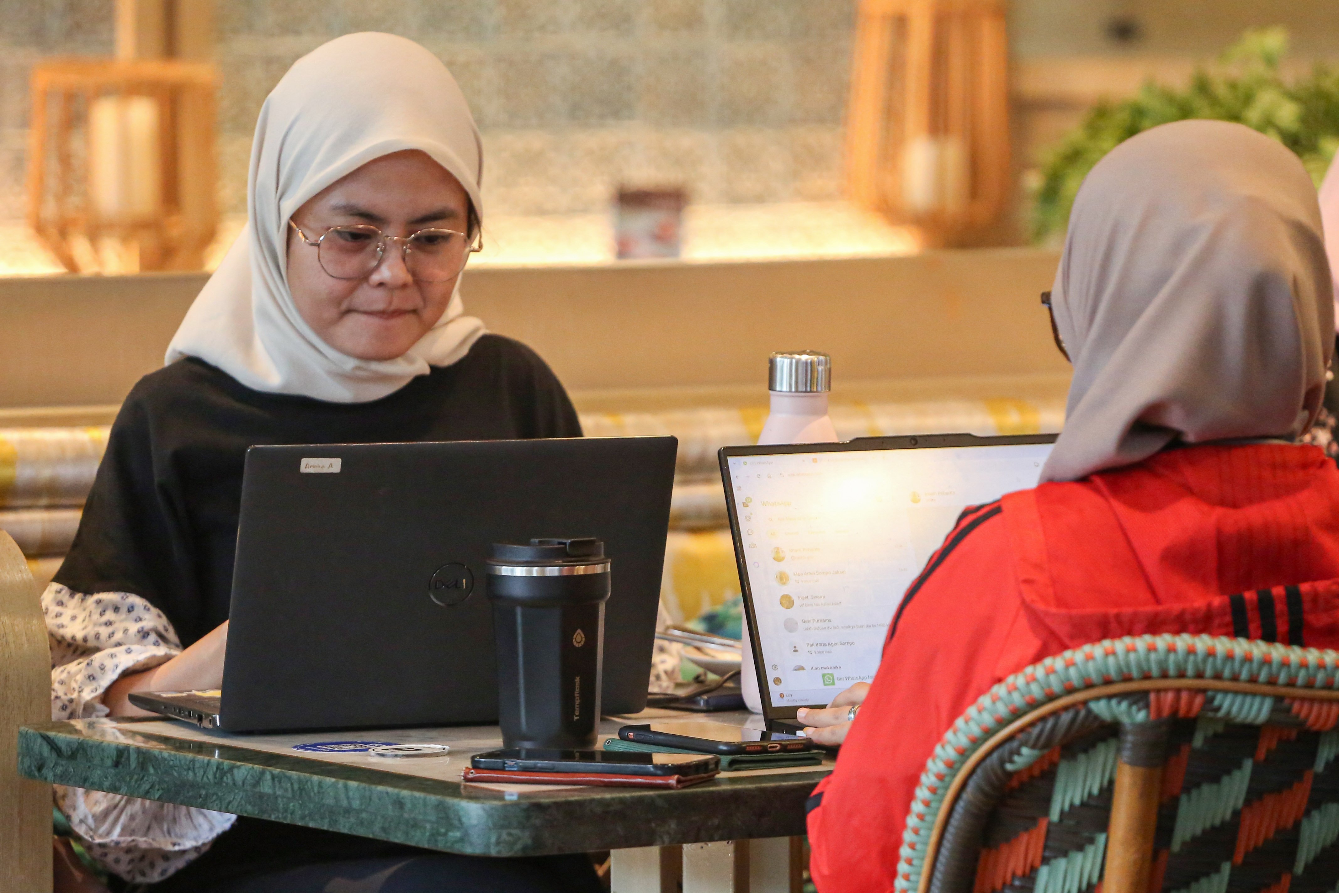 Pengunjung menggunakan laptopnya saat bekerja di Mal Kota Kasablanka, Jakarta, Selasa (30/12/2025). Pemerintah mencanangkan konsep bekerja dari mal atau work from mall (WFM) untuk mendorong pemanfaatan pusat perbelanjaan sebagai ruang kerja alternatif dalam upaya menjaga aktivitas ekonomi tetap bergerak di tengah momentum libur panjang akhir tahun.