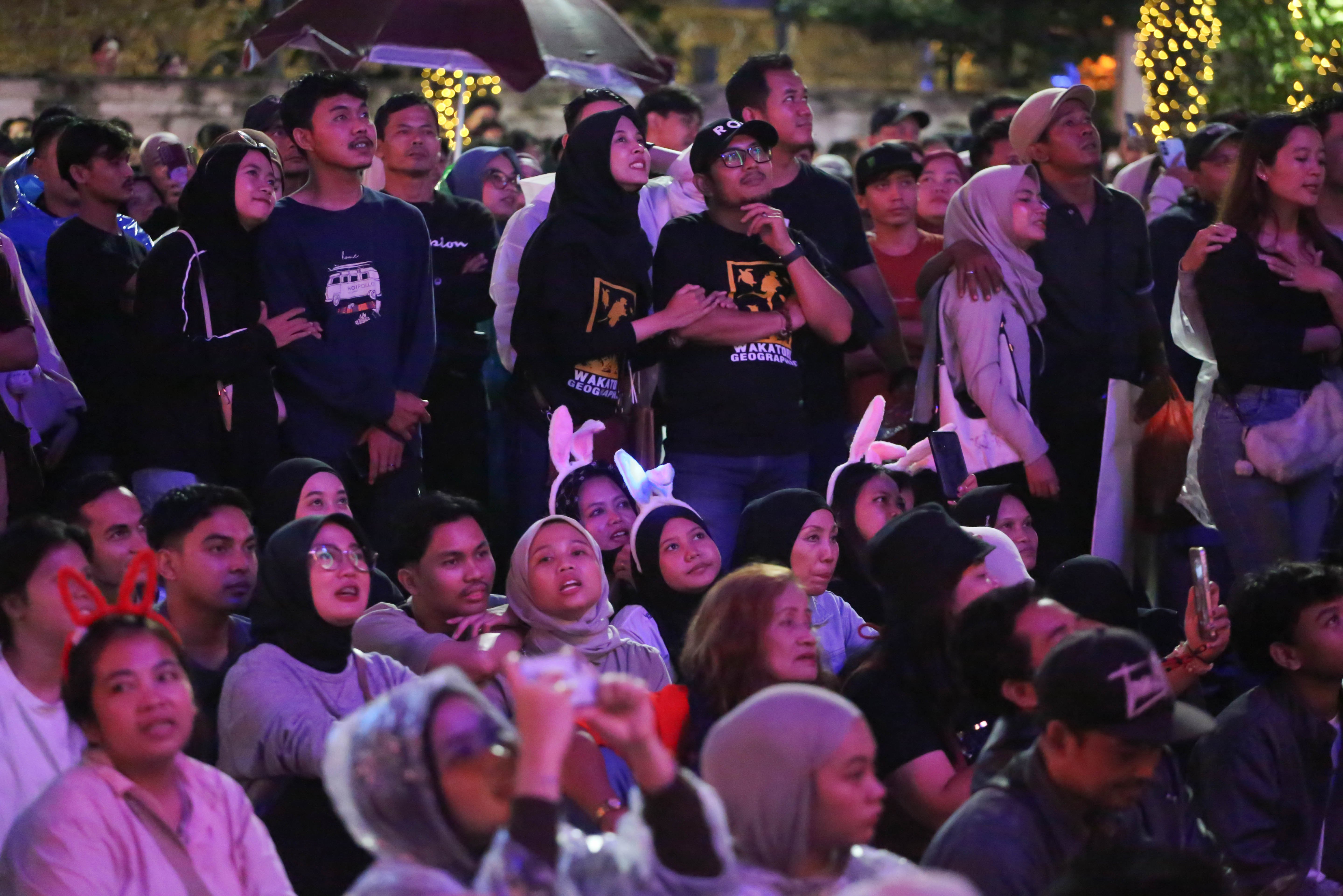 Warga menyaksikan pertunjukkan musik pada acara menyambut malam Tahun Baru 2026 di Bundaran HI, Jakarta, Rabu (31/12/2025). Acara yang mengusung tema \