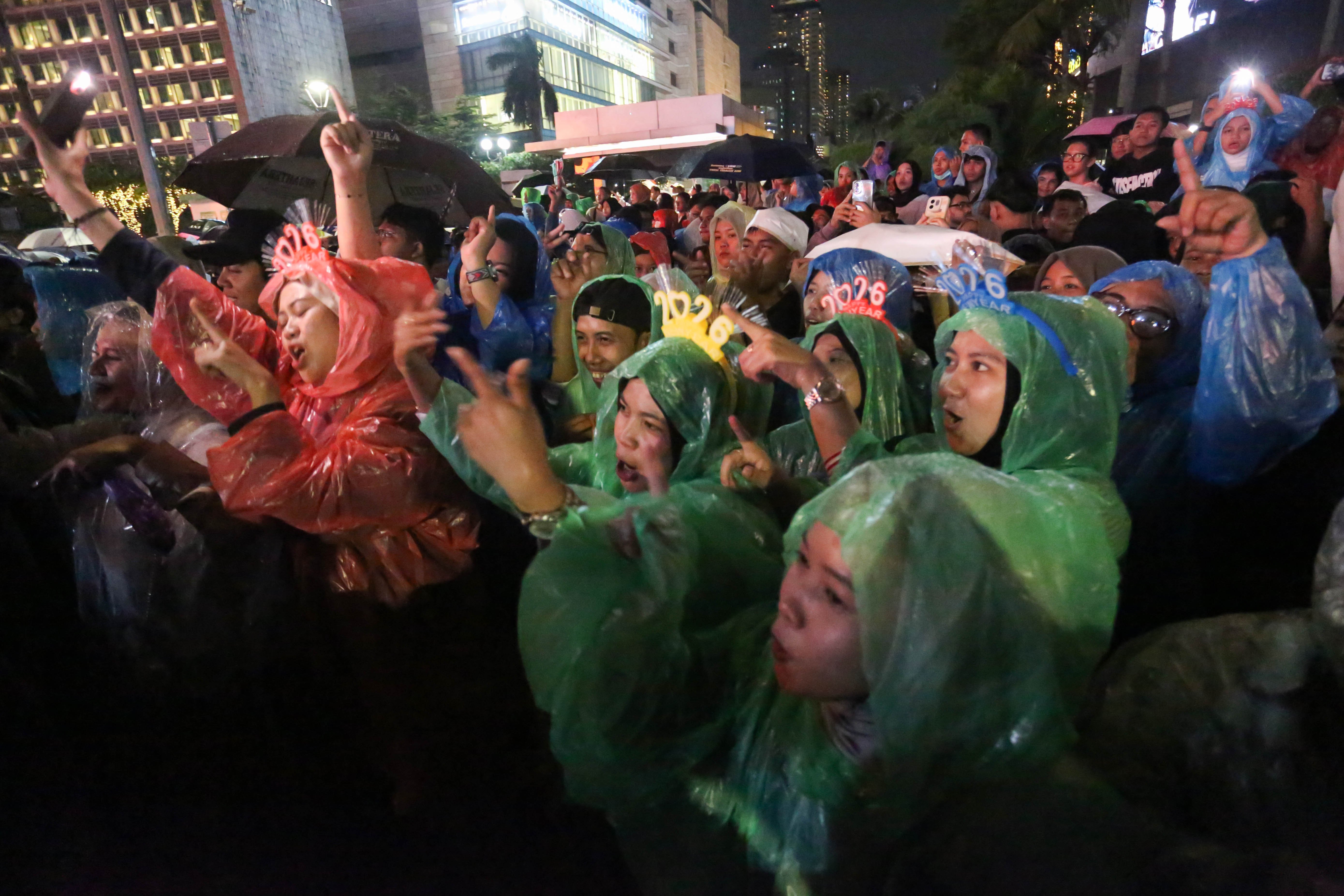Warga menyanyi saat grup musik Feel Koplo tampil pada acara menyambut malam Tahun Baru 2026 di Bundaran HI, Jakarta, Rabu (31/12/2025). Acara yang mengusung tema \