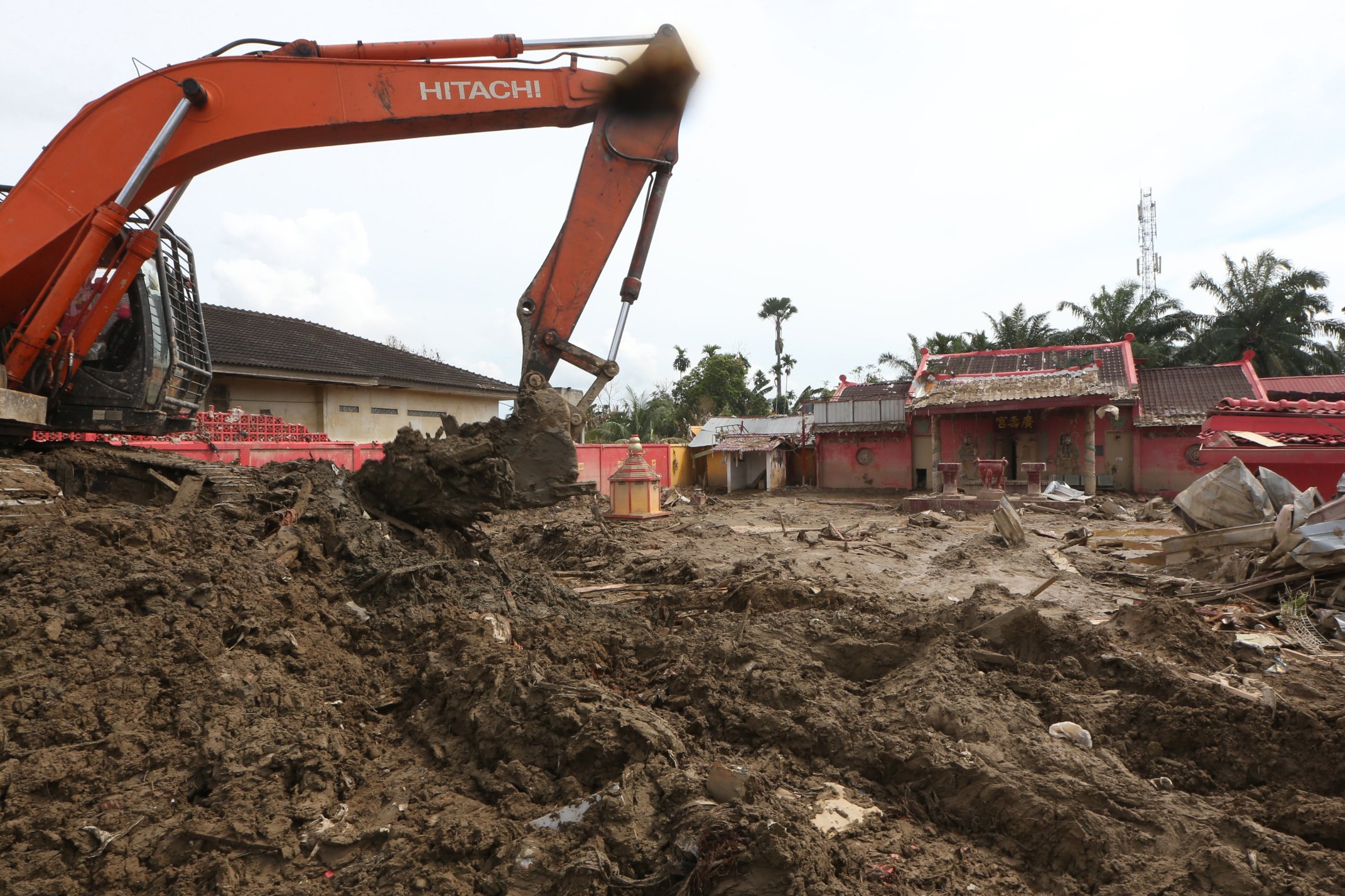 Relawan Arta Graha Peduli dengan menggunakan alat berat membersihkan lumpur dan gelondongan kayu di Vihara Co Su Kong, Kuala Simpang, Aceh Tamiang, Aceh, Senin (29/12/2025). Data posko penanggulangan bencana hidrometeorologi Kabupaten Aceh Tamiang menyebutkan sebanyak 60 unit rumah ibadah rusak dan tertimbun lumpur akibat banjir bandang 26 November lalu. 