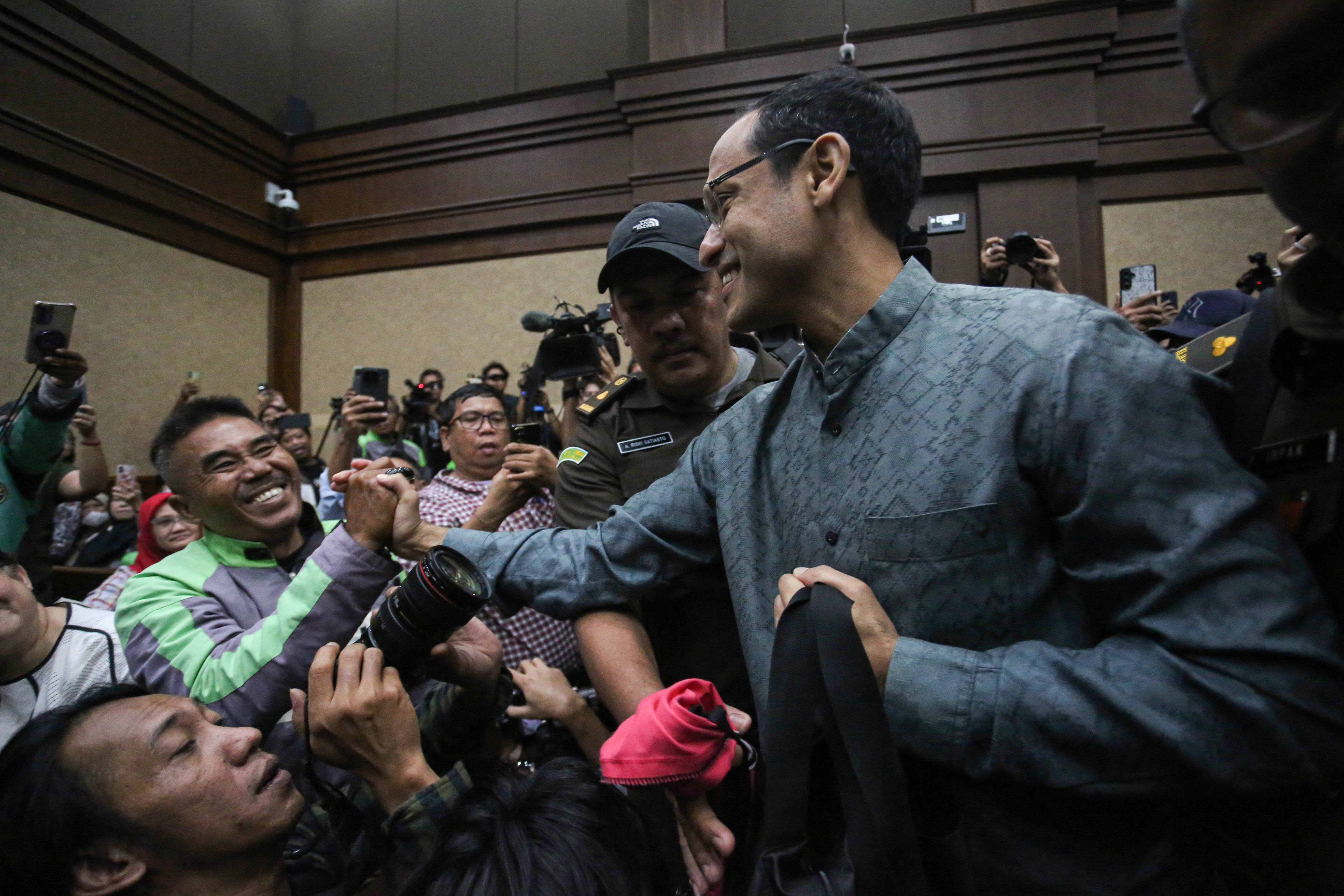 Tersangka kasus dugaan korupsi pengadaan laptop Chromebook di Kemendikbudristek 2019-2022, Nadiem Makarim (kanan) menyapa pengemudi ojek daring yang menghadiri sidang dakwaan di Pengadilan Negeri Jakarta Pusat, Senin (5/1/2026). Jaksa Penuntut Umum mendakwa Nadiem memperkaya diri sendiri senilai Rp 809.596.125.000 dengan dugaan mengakibatkan kerugian negara Rp 2,1 triliun dalam kasus dugaan pengadaan laptop Chromebook di Kemendikbudristek.