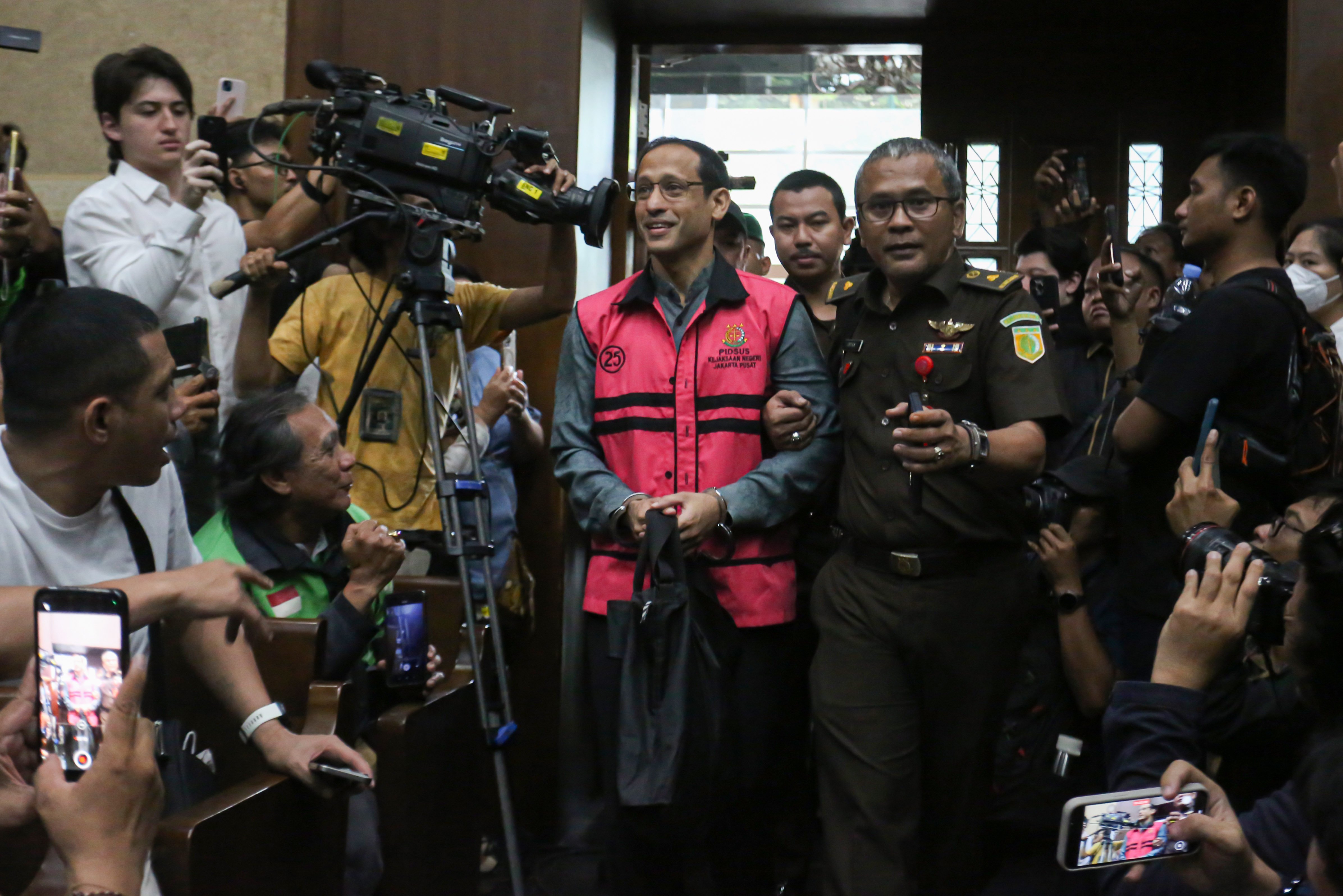 Tersangka kasus dugaan korupsi pengadaan laptop Chromebook dalam program digitalisasi di Kemendikbudristek 2019-2022, Nadiem Makarim (tengah) memasuki ruang sidang di Pengadilan Negeri Jakarta Pusat, Senin (5/1/2026). Jaksa Penuntut Umum mendakwa Nadiem memperkaya diri sendiri senilai Rp 809.596.125.000 dengan dugaan mengakibatkan kerugian negara Rp 2,1 triliun dalam kasus dugaan pengadaan laptop Chromebook di Kemendikbudristek.