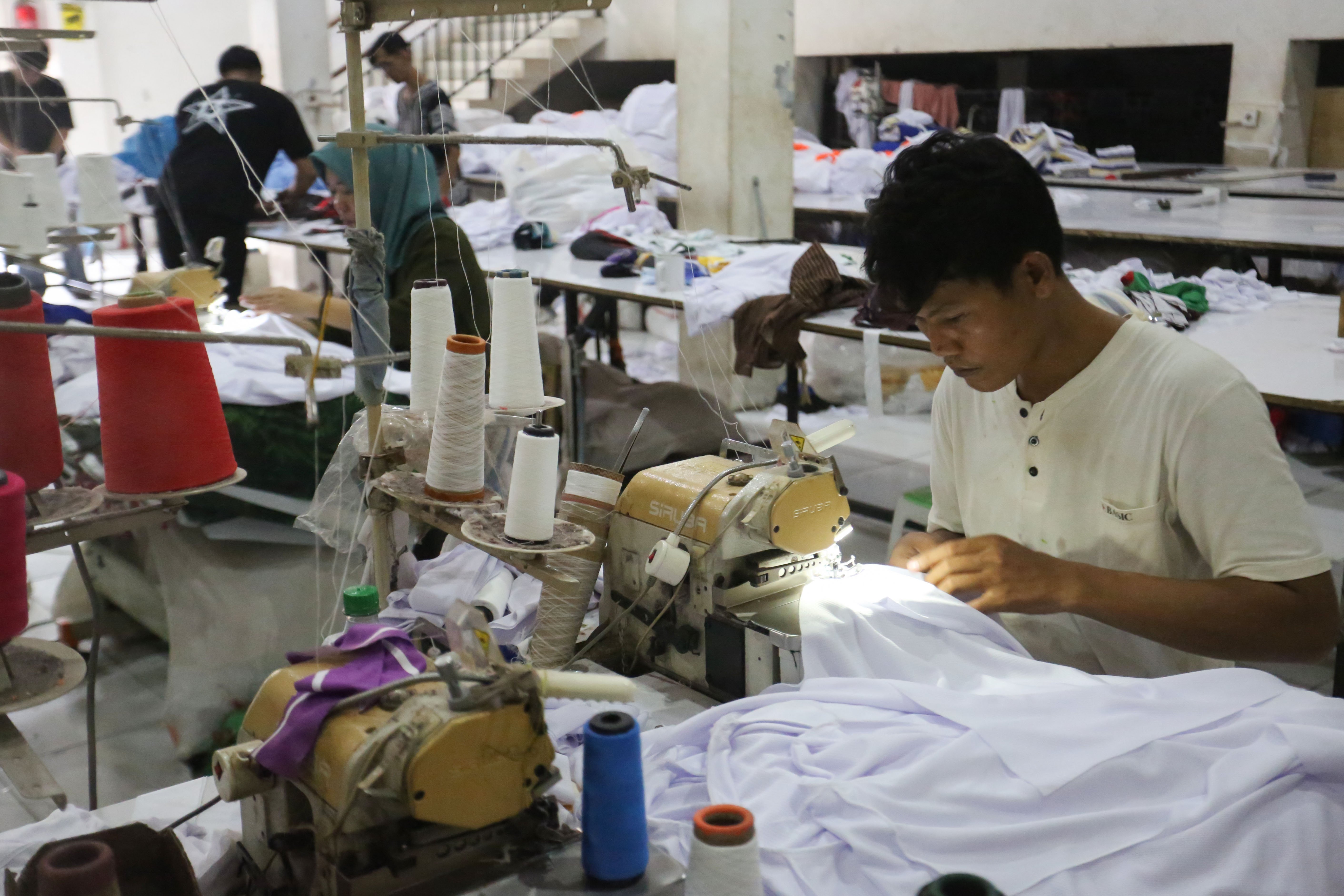 Pekerja menyelesaikan pembuatan kaos di konveksi Sinergi Adv Nusantara, Srengseng Sawah, Jakarta Selatan, Jumat (9/1/2026). Sebagai bagian dari paket stimulus ekonomi tahun anggaran 2026 Pemerintah resmi menanggung Pajak Penghasilan (PPh) Pasal 21 untuk pekerja di lima sektor padat karya di antaranya industri alas kaki, tekstil dan pakaian jadi, furnitur, kulit dan barang dari kulit, serta pariwisata. 