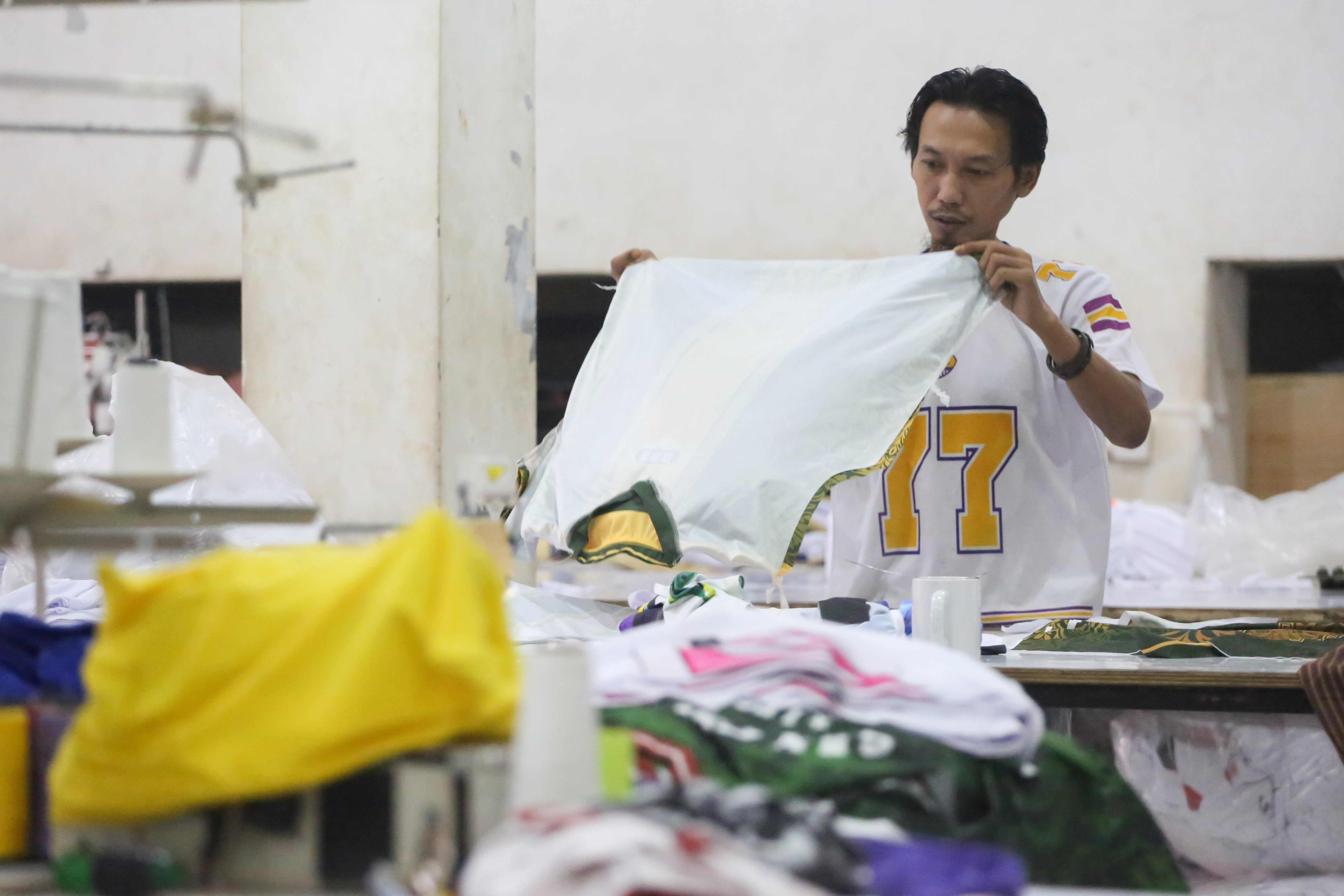 Pekerja menyelesaikan pembuatan kaos di konveksi Sinergi Adv Nusantara, Srengseng Sawah, Jakarta Selatan, Jumat (9/1/2026). Sebagai bagian dari paket stimulus ekonomi tahun anggaran 2026 Pemerintah resmi menanggung Pajak Penghasilan (PPh) Pasal 21 untuk pekerja di lima sektor padat karya di antaranya industri alas kaki, tekstil dan pakaian jadi, furnitur, kulit dan barang dari kulit, serta pariwisata. 