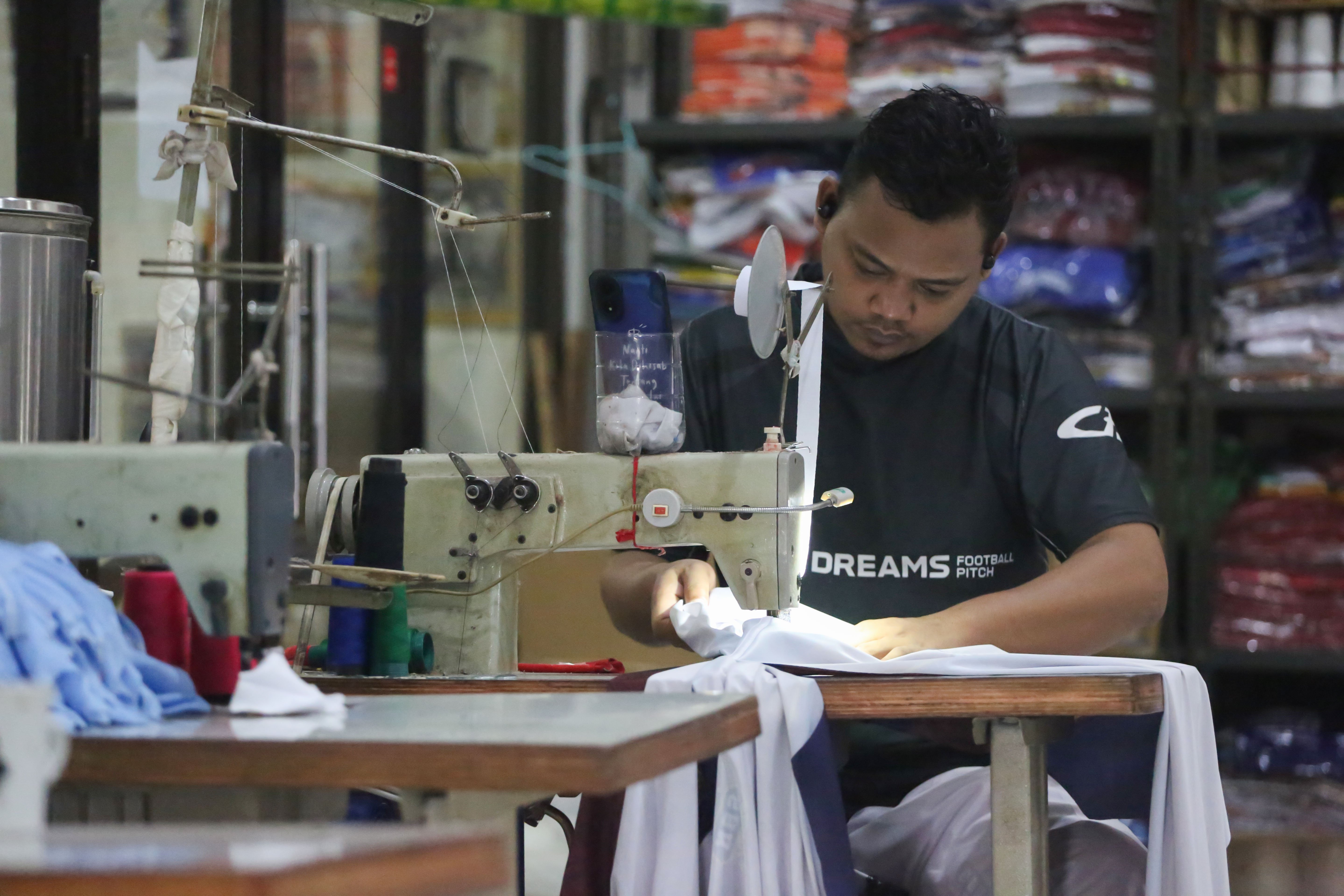 Pekerja menyelesaikan pembuatan kaos di konveksi Sinergi Adv Nusantara, Srengseng Sawah, Jakarta Selatan, Jumat (9/1/2026). Sebagai bagian dari paket stimulus ekonomi tahun anggaran 2026 Pemerintah resmi menanggung Pajak Penghasilan (PPh) Pasal 21 untuk pekerja di lima sektor padat karya di antaranya industri alas kaki, tekstil dan pakaian jadi, furnitur, kulit dan barang dari kulit, serta pariwisata. 