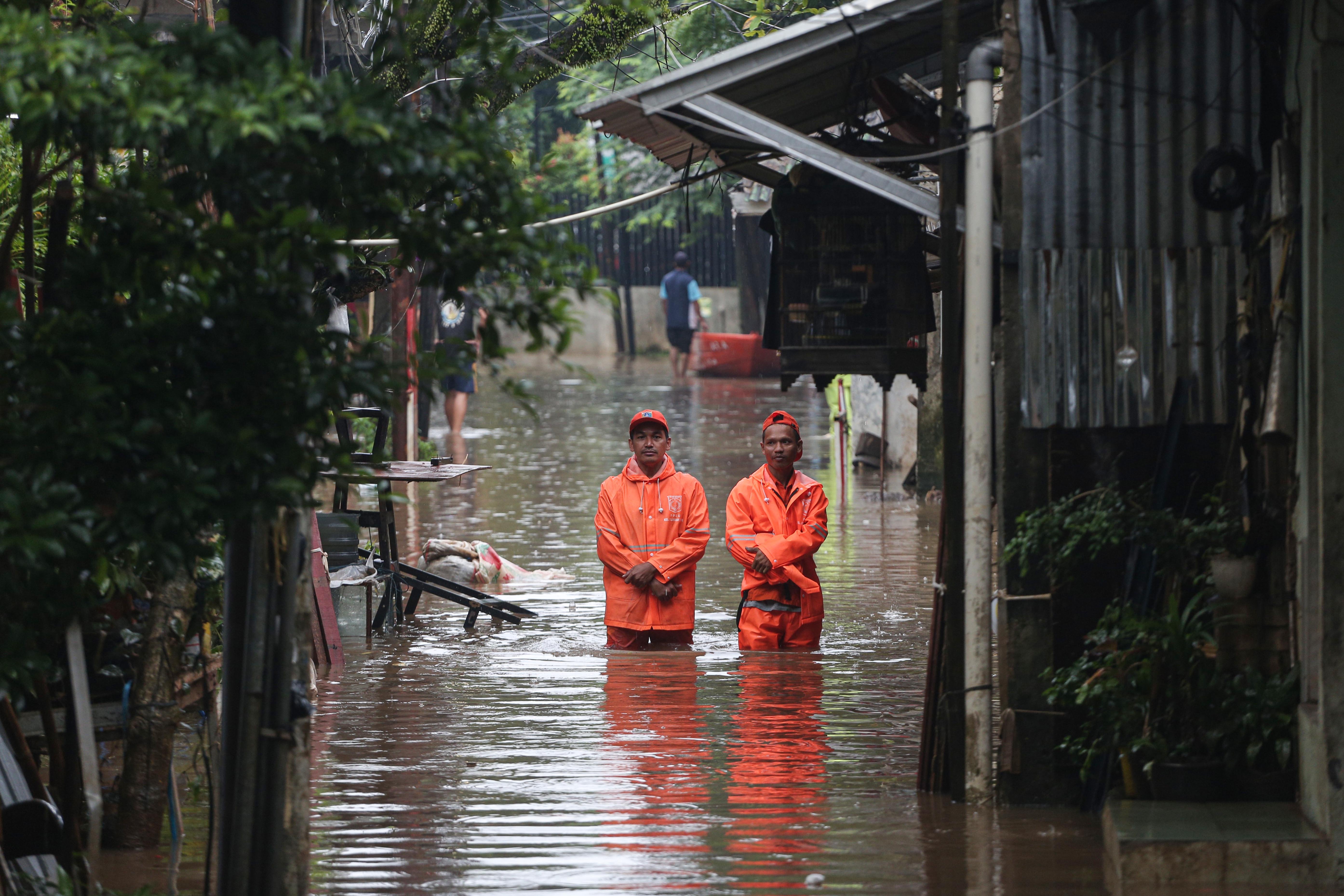 Petugas Penanganan Prasarana dan Sarana Umum (PPSU) berjalan melintasi banjir yang merendam wilayah Cilandak Timur, Kecamatan Pasar Minggu, Jakarta Selatan, Senin (12/1/2026). Banjir setinggi 20-70 sentimeter yang menggenangi kawasan tersebut disebabkan oleh curah hujan tinggi dan meluapnya Kali Krukut.