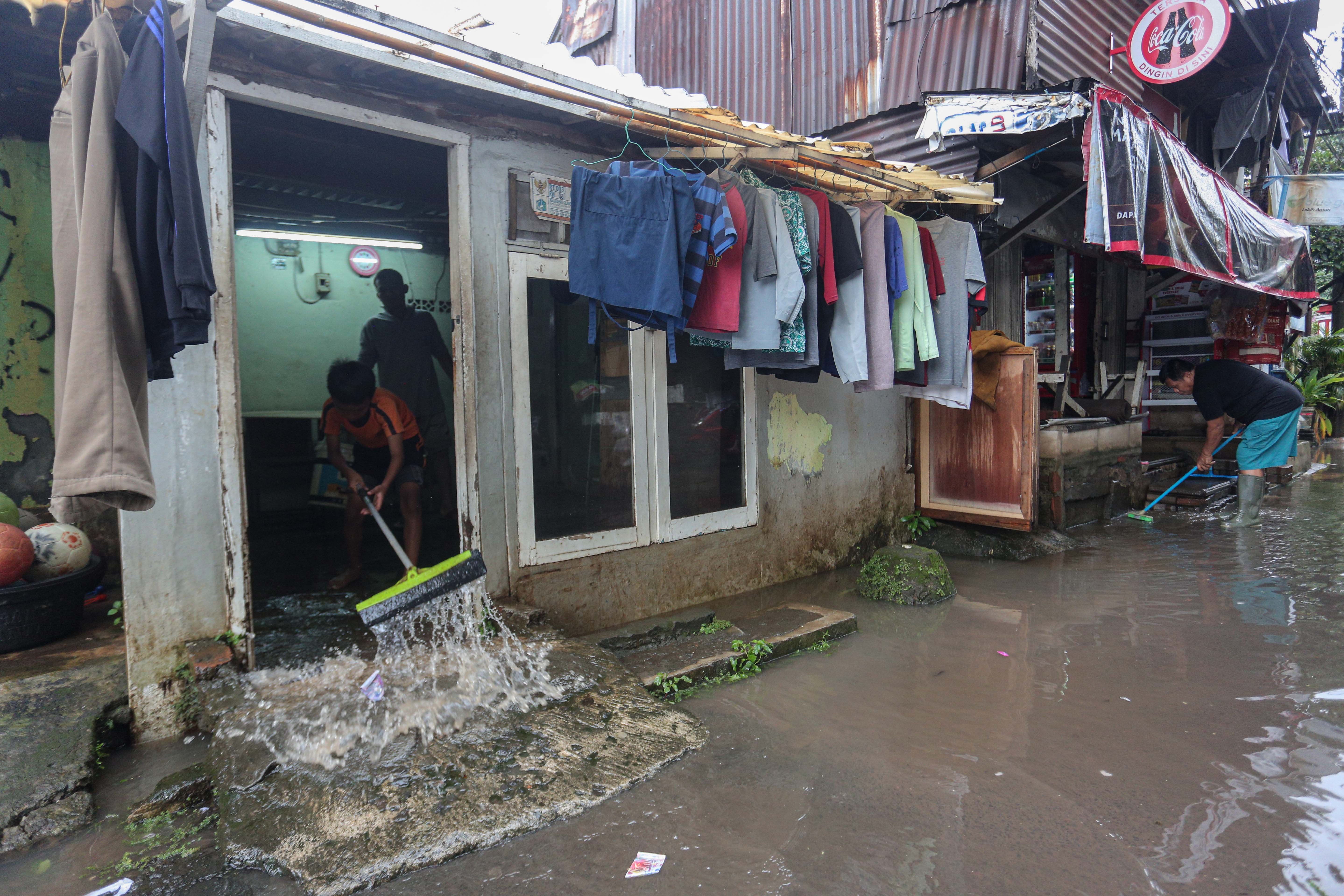 Warga membersihkan rumahnya yang terendam banjir wilayah Cilandak Timur, Kecamatan Pasar Minggu, Jakarta Selatan, Senin (12/1/2026). Banjir setinggi 20-70 sentimeter yang menggenangi kawasan tersebut disebabkan oleh curah hujan tinggi dan meluapnya Kali Krukut.