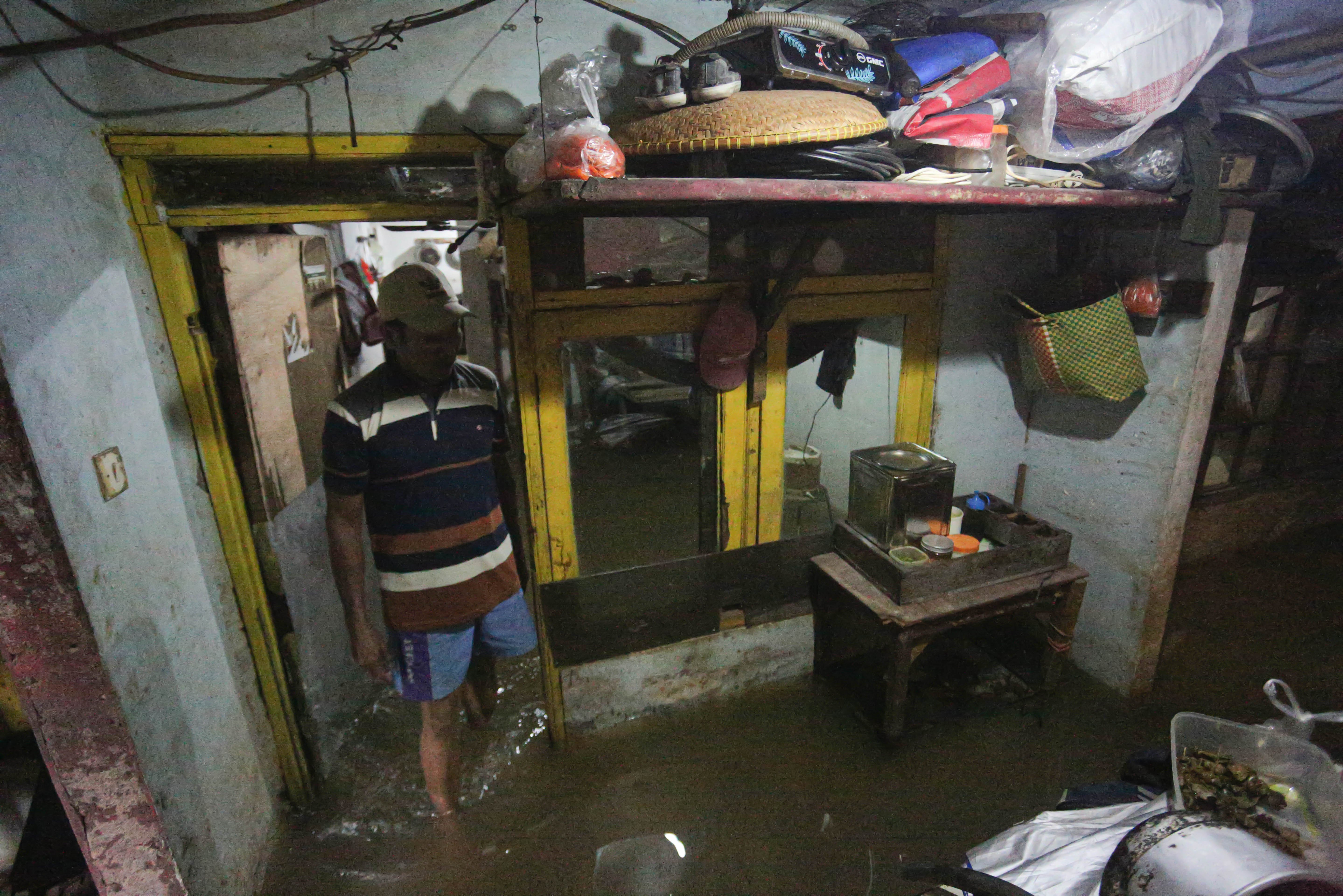 Warga berada di dalam rumahnya yang terendam banjir di wilayah Cilandak Timur, Kecamatan Pasar Minggu, Jakarta Selatan, Senin (12/1/2026). Banjir setinggi 20-70 sentimeter yang menggenangi kawasan tersebut disebabkan oleh curah hujan tinggi dan meluapnya Kali Krukut.
