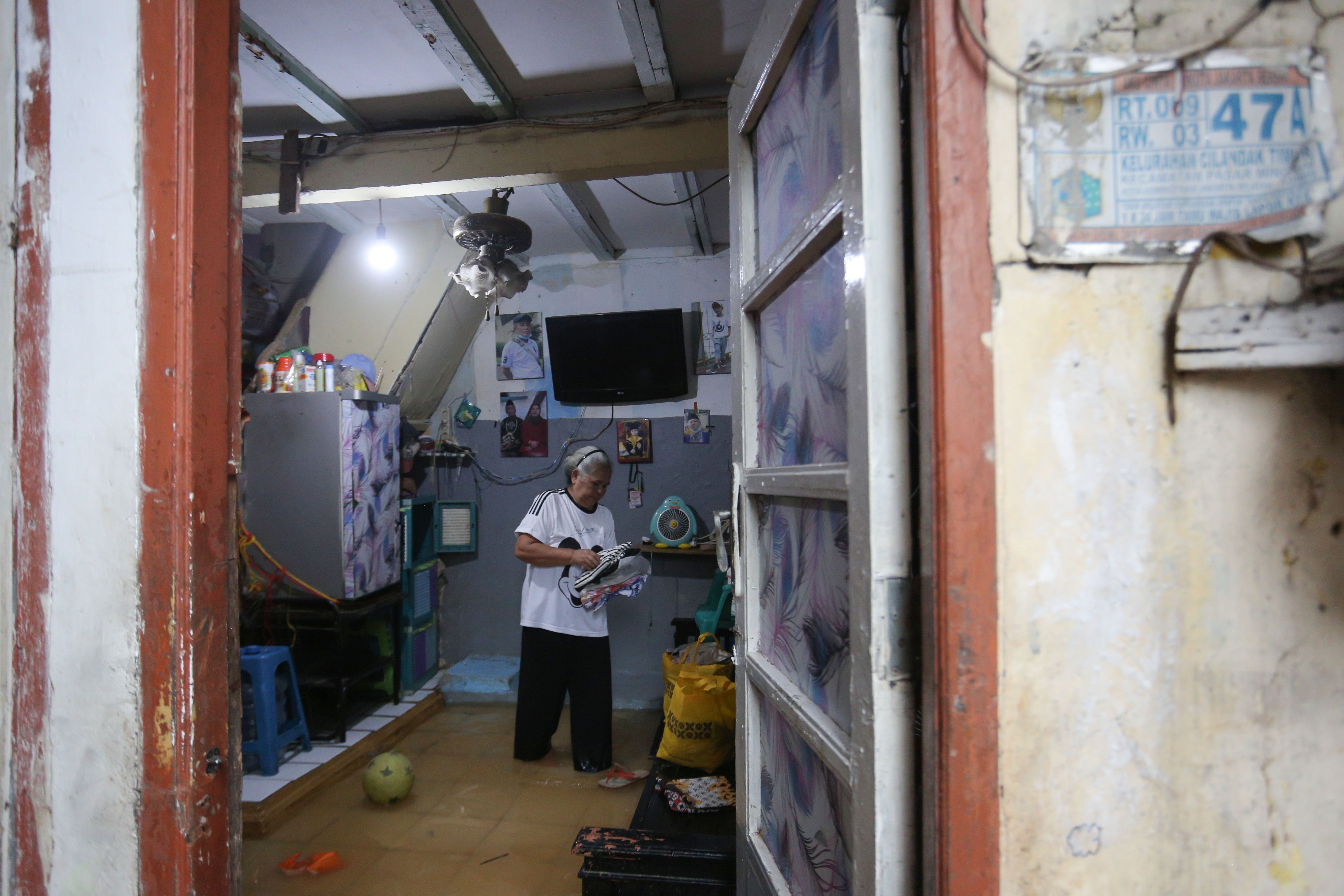 Warga berada di dalam rumahnya yang terendam banjir di wilayah Cilandak Timur, Kecamatan Pasar Minggu, Jakarta Selatan, Senin (12/1/2026). Banjir setinggi 20-70 sentimeter yang menggenangi kawasan tersebut disebabkan oleh curah hujan tinggi dan meluapnya Kali Krukut.