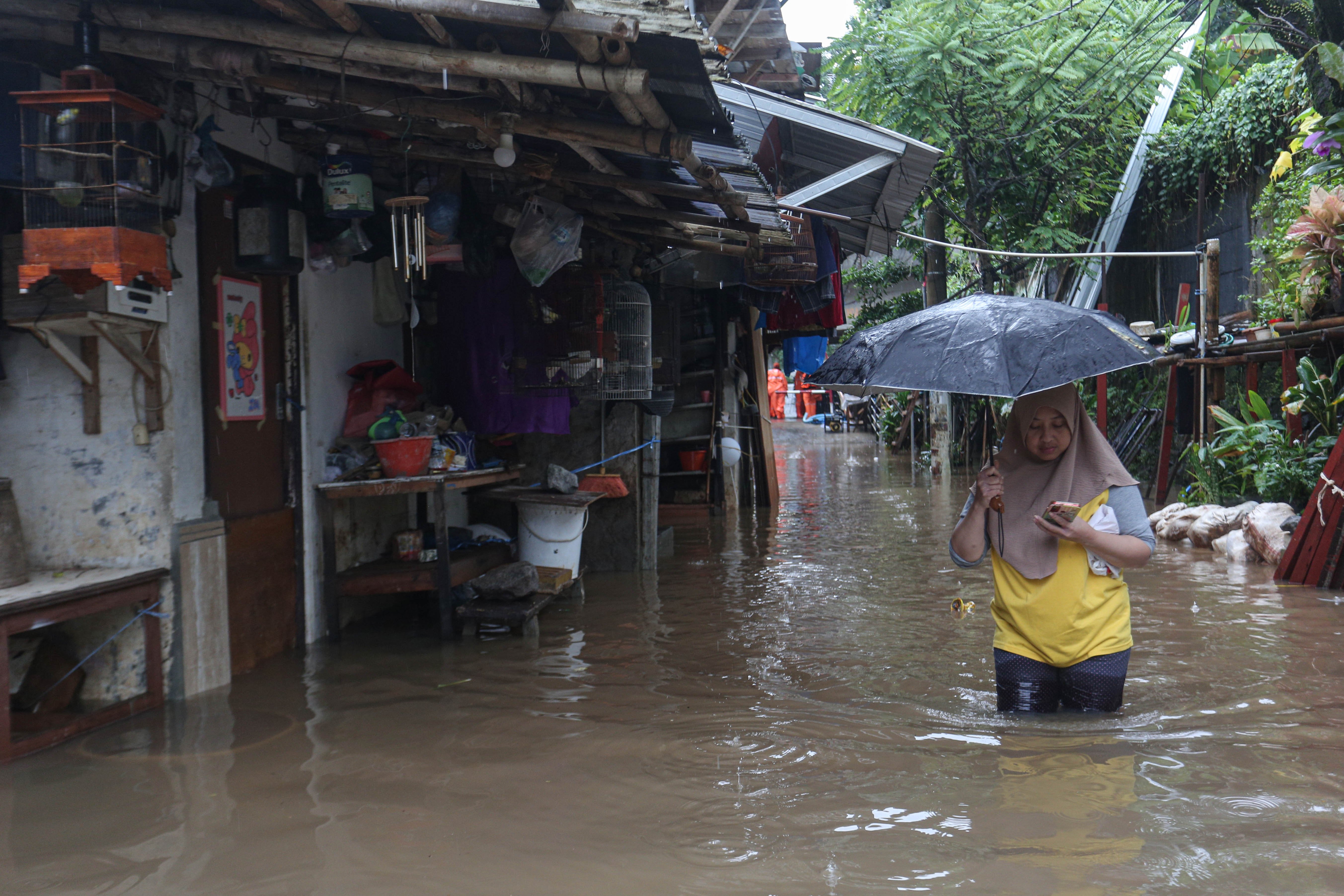 Warga berjalan melintasi banjir yang merendam wilayah Cilandak Timur, Kecamatan Pasar Minggu, Jakarta Selatan, Senin (12/1/2026). Banjir setinggi 20-70 sentimeter yang menggenangi kawasan tersebut disebabkan oleh curah hujan tinggi dan meluapnya Kali Krukut.