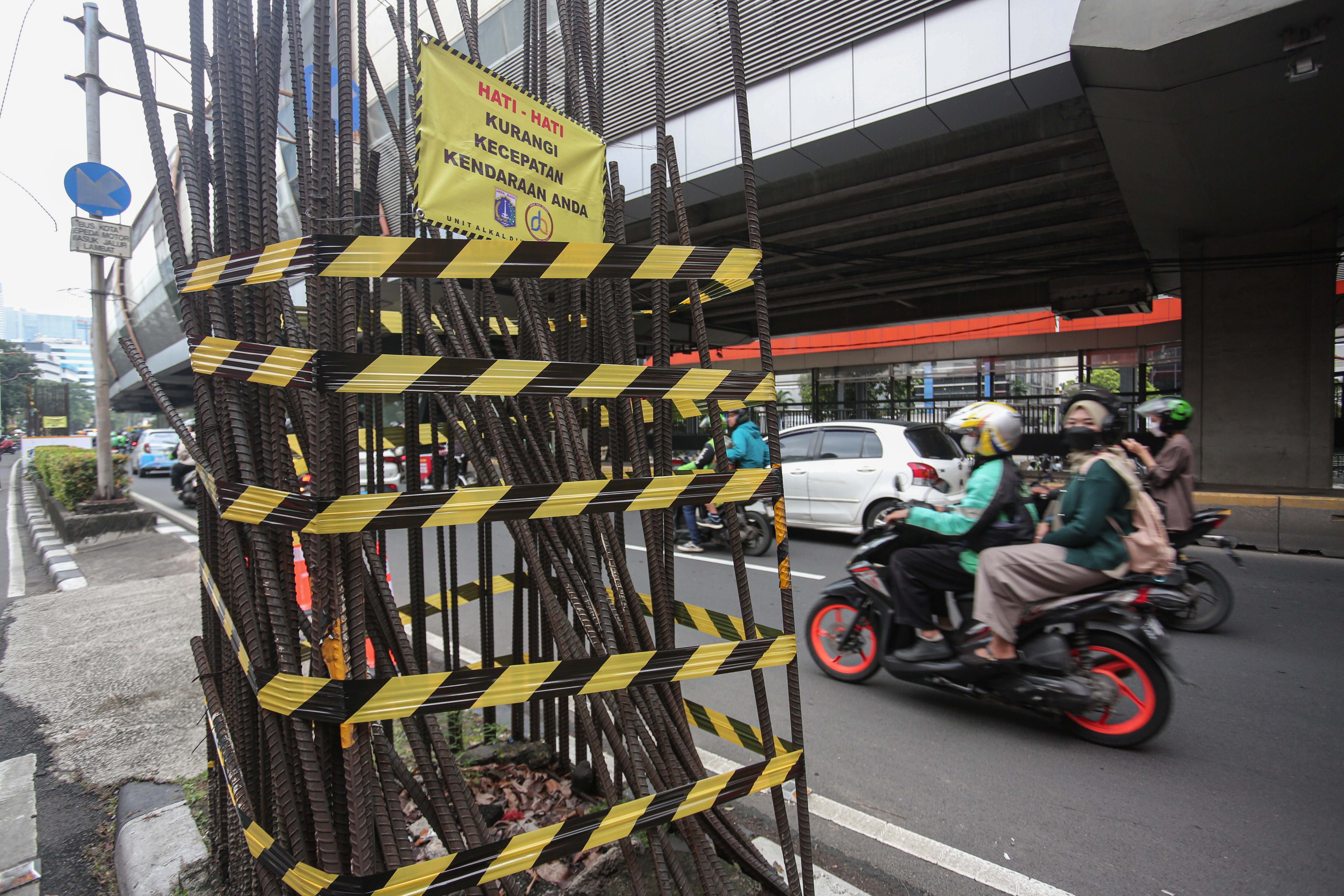 Pengendara sepeda motor melintas di dekat tiang monorel yang akan dibongkar di Jalan H.R. Rasuna Said, Kuningan, Jakarta Selatan, Rabu (14/1/2026). Pemerintah Provinsi DKI Jakarta mulai membongkar 109 tiang monorel yang mangkrak dan akan menata pedestrian di kawasan Rasuna Said dengan mengalokasikan anggaran Rp102 miliar.