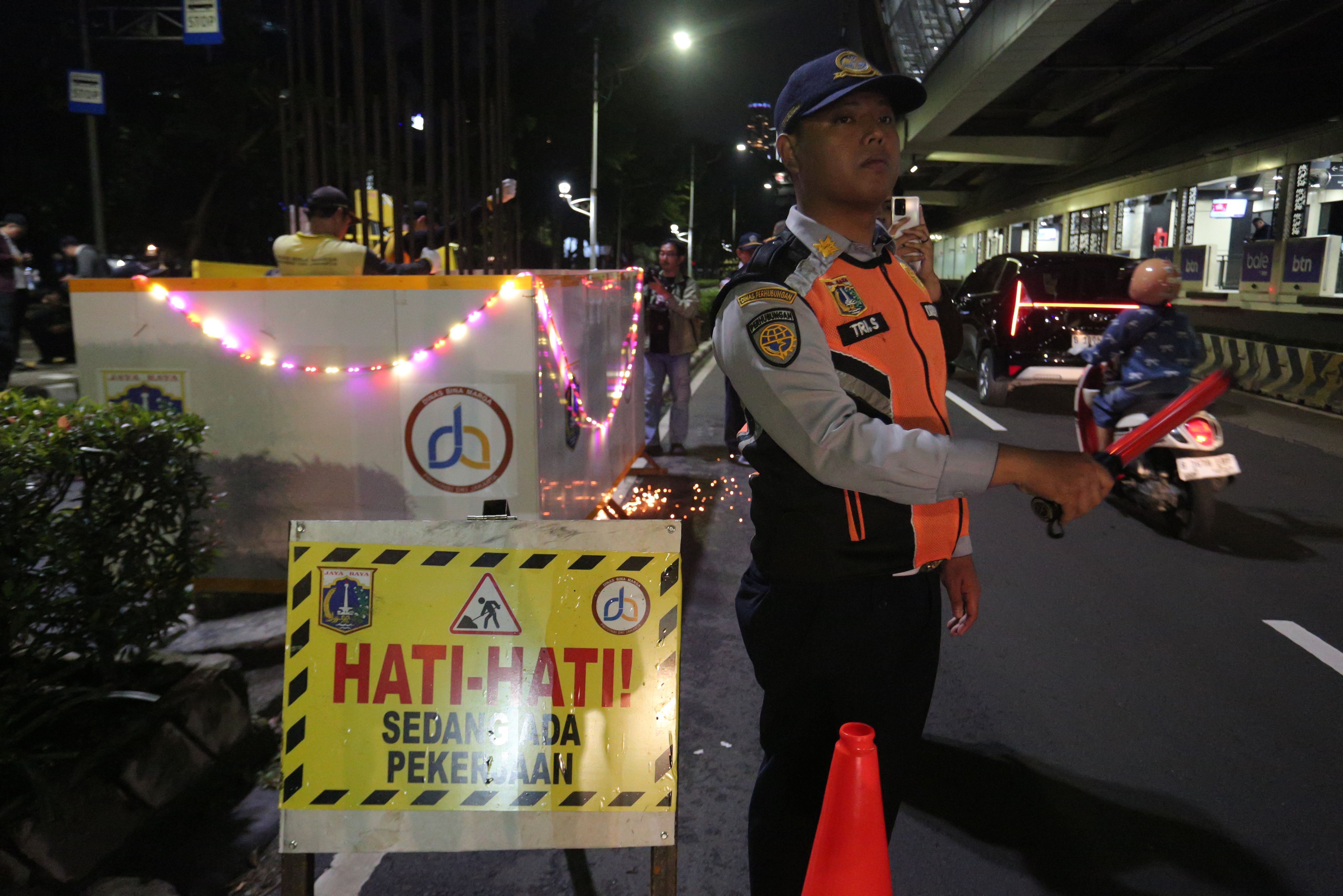 Petugas Dinas Perhubungan mengatur lalu lintas saat pembongkaran tiang monorel yang mangkrak di Jalan H.R. Rasuna Said, Kuningan, Jakarta Selatan, Rabu (14/1/2026). Pemerintah Provinsi DKI Jakarta membongkar tiang monorel yang mangkrak dan akan menata kawasan tersebut dengan membangun taman, ruas jalan, hingga pedestrian untuk meningkatkan keindahan kota serta mengurangi kemacetan.