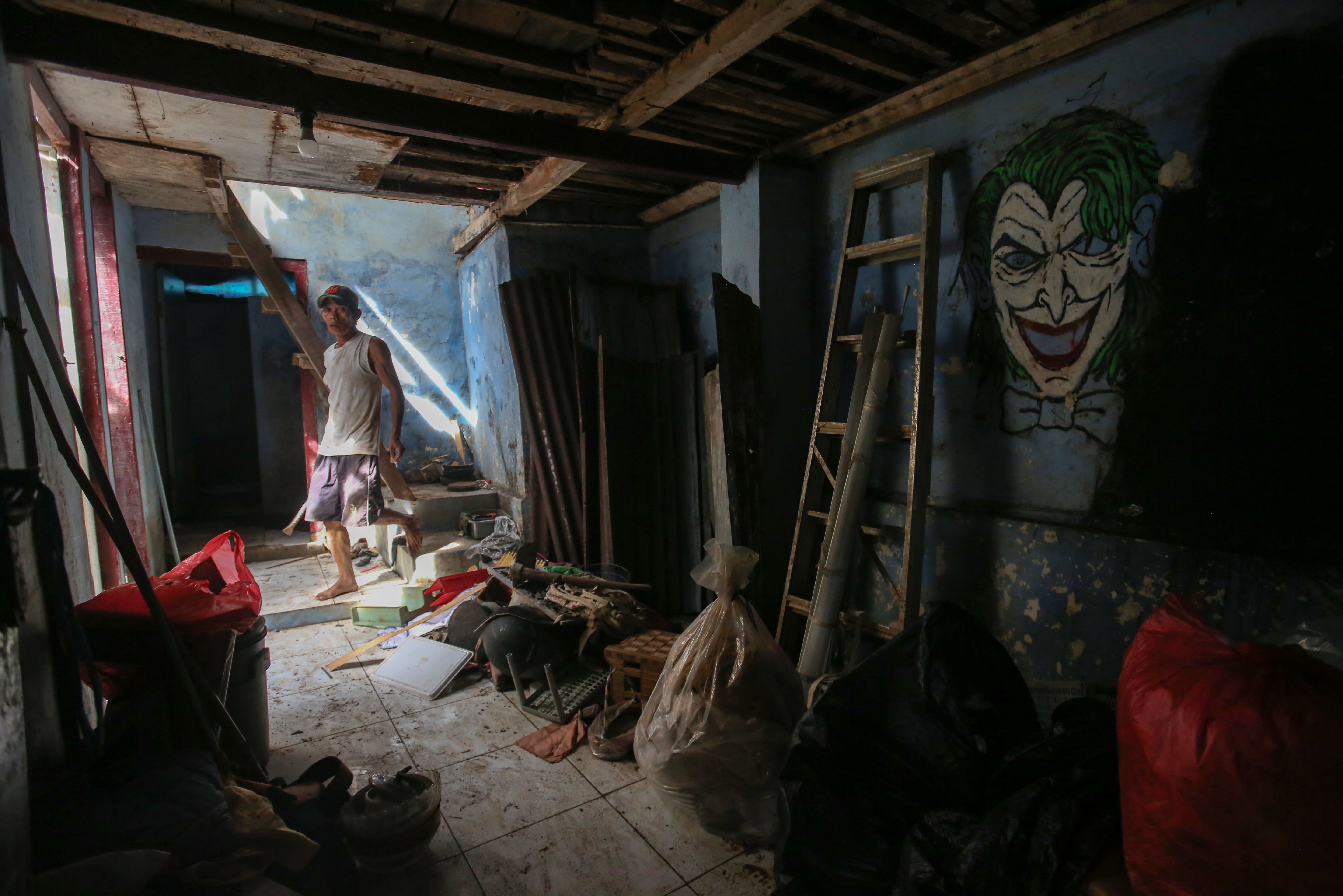 Warga berada di dalam rumahnya saat pembongkaran di bantaran Kali Ciliwung, Taman Harapan, Cawang, Jakarta Timur, Jumat (6/2/2026). Pemprov DKI Jakarta membebaskan lahan dengan membongkar rumah warga untuk proyek normalisasi Kali Ciliwung sebagai langkah untuk mengatasi banjir yang kerap terjadi di wilayah tersebut.