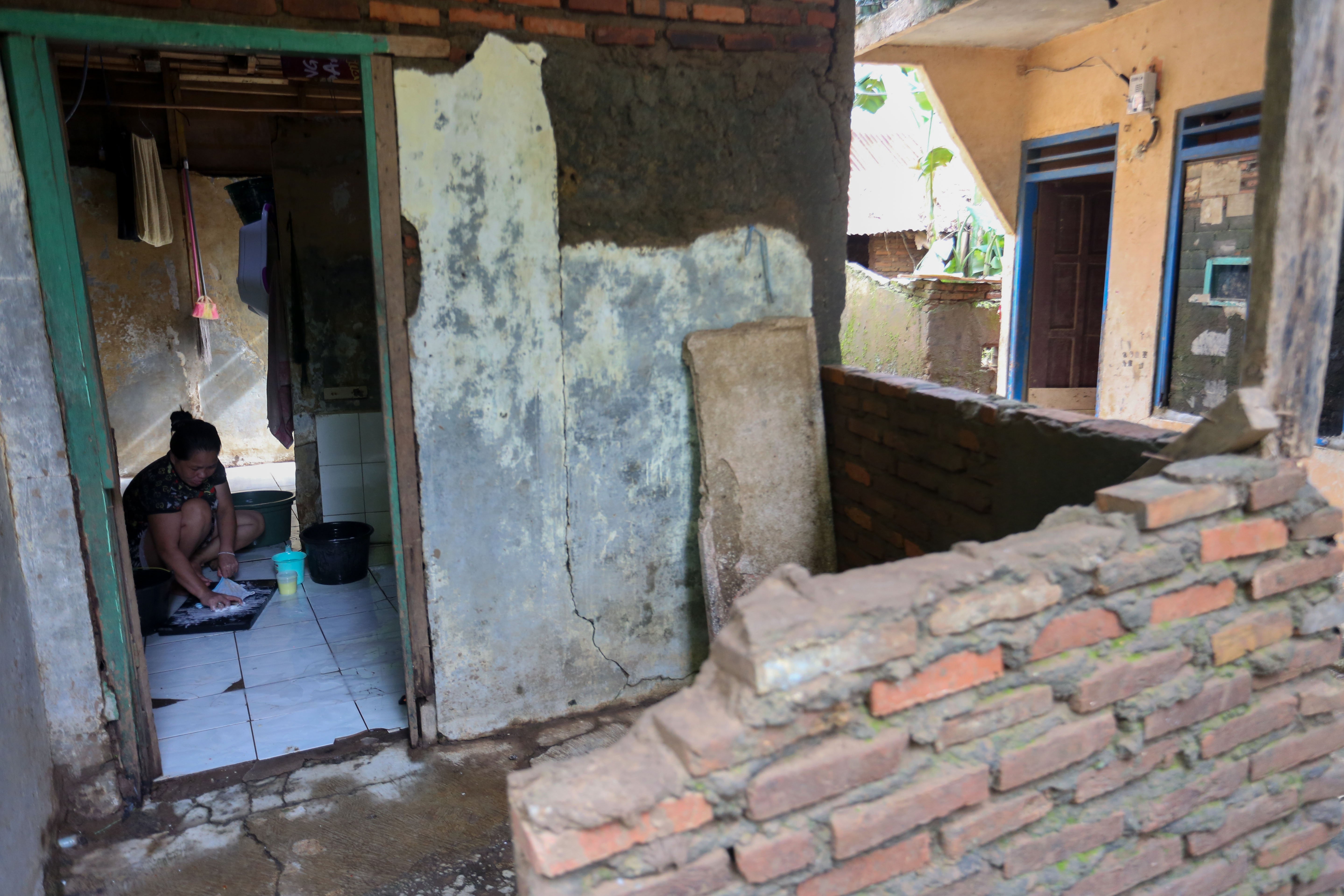 Warga mencuci pakaian di dalam rumahnya yang berada di bantaran Kali Ciliwung, Taman Harapan, Cawang, Jakarta Timur, Jumat (6/2/2026). Pemprov DKI Jakarta membebaskan lahan dengan membongkar rumah warga untuk proyek normalisasi Kali Ciliwung sebagai langkah untuk mengatasi banjir yang kerap terjadi di wilayah tersebut.