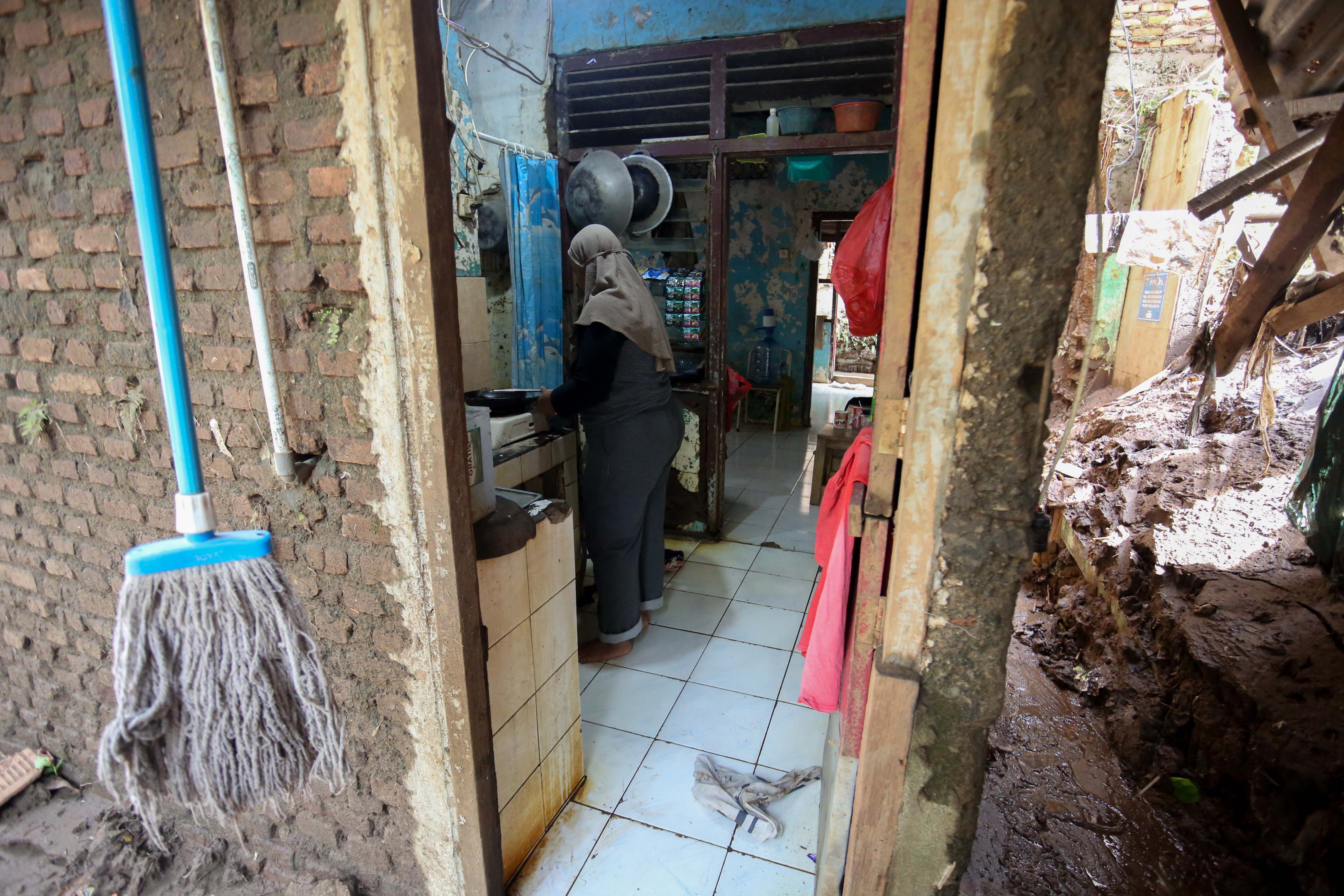 Warga beraktivitas di dalam rumahnya yang berada di bantaran Kali Ciliwung, Taman Harapan, Cawang, Jakarta Timur, Jumat (6/2/2026). Pemprov DKI Jakarta membebaskan lahan dengan membongkar rumah warga untuk proyek normalisasi Kali Ciliwung sebagai langkah untuk mengatasi banjir yang kerap terjadi di wilayah tersebut.