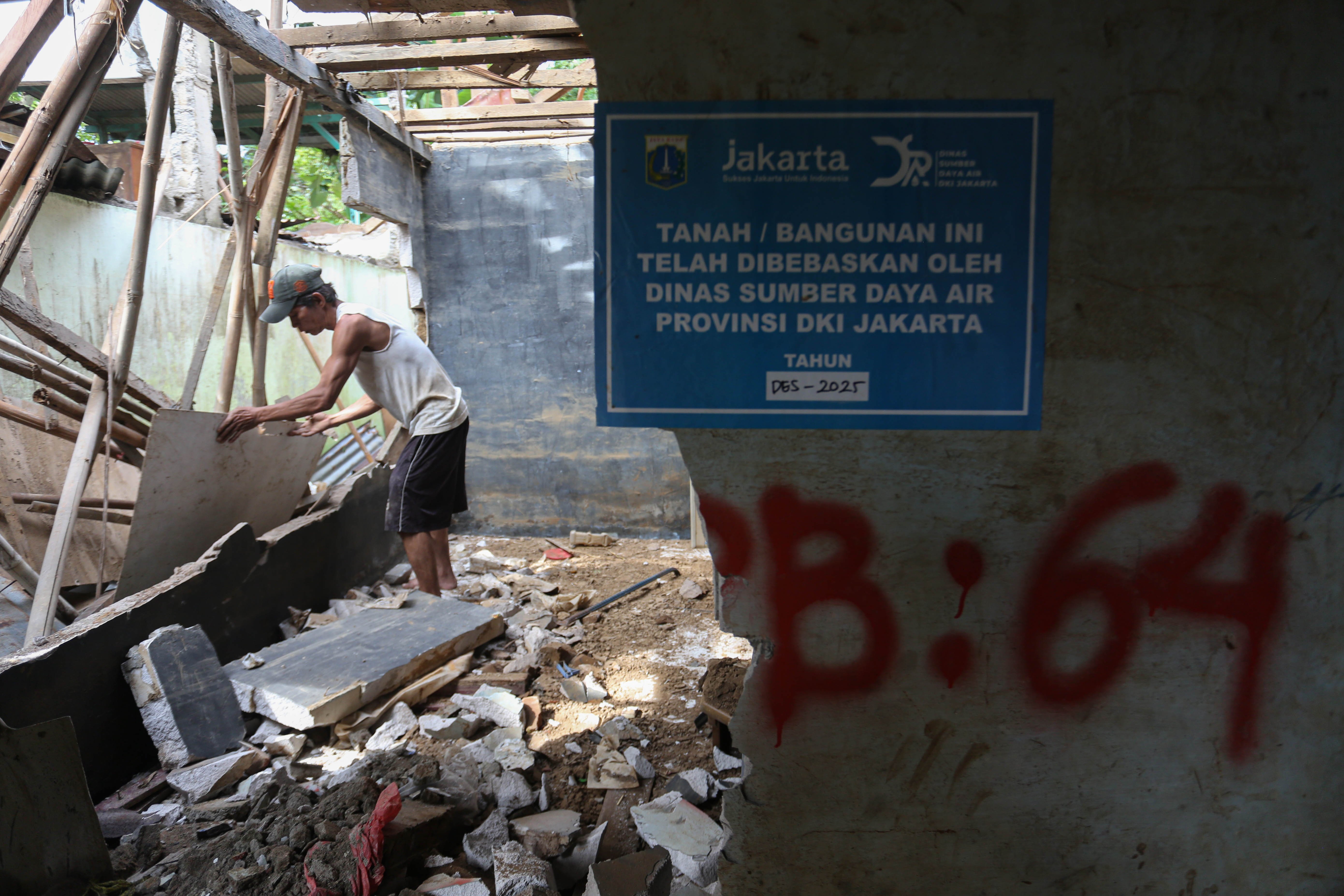 Warga membongkar rumahnya yang berada di bantaran Kali Ciliwung, Taman Harapan, Cawang, Jakarta Timur, Jumat (6/2/2026). Pemprov DKI Jakarta membebaskan lahan dengan membongkar rumah warga untuk proyek normalisasi Kali Ciliwung sebagai langkah untuk mengatasi banjir yang kerap terjadi di wilayah tersebut.