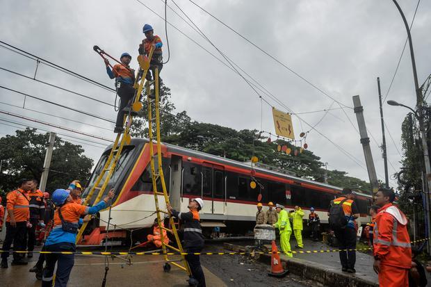 Petugas memutus kabel listrik saat mengevakuasi kereta api (KA) Bandara Soekarno-Hatta yang anjlok di Poris, Kota Tangerang, Banten, Jumat (20/2/2026). Kereta api Bandara Soekarno-Hatta tersebut mengalami anjlok setelah menabrak truk di pelintasan sebidang JPL 21 sehingga menutup akses jalan dan membuat rute perjalanan KRL terganggu.