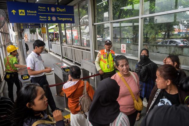 Penumpang KRL Commuter Line berdiri di depan gerbang tiket setelah batalnya perjalanannya akibat kereta api (KA) Bandara Soekarno-Hatta anjlok di Stasiun Tanah Tinggi, Kota Tangerang, Banten, Jumat (20/2/2026). Perjalanan KRL lintas rute Duri - Tangerang mengalami gangguan akibat KA Bandara Soekarno-Hatta yang anjlok setelah menabrak truk di pelintasan sebidang JPL 21 sehingga layanan perjalanan kereta untuk sementara hanya sampai Stasiun Rawa Buaya.