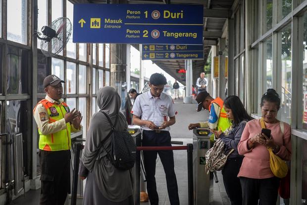 Petugas menyampaikan penjelasan kepada penumpang KRL Commuter Line yang terdampak gangguan akibat anjloknya kereta api (KA) Bandara Soekarno-Hatta di Stasiun Tanah Tinggi, Kota Tangerang, Banten, Jumat (20/2/2026). Perjalanan KRL lintas rute Duri - Tangerang mengalami gangguan akibat KA Bandara Soekarno-Hatta yang anjlok setelah menabrak truk di pelintasan sebidang JPL 21 sehingga layanan perjalanan kereta untuk sementara hanya sampai di Stasiun Rawa Buaya.