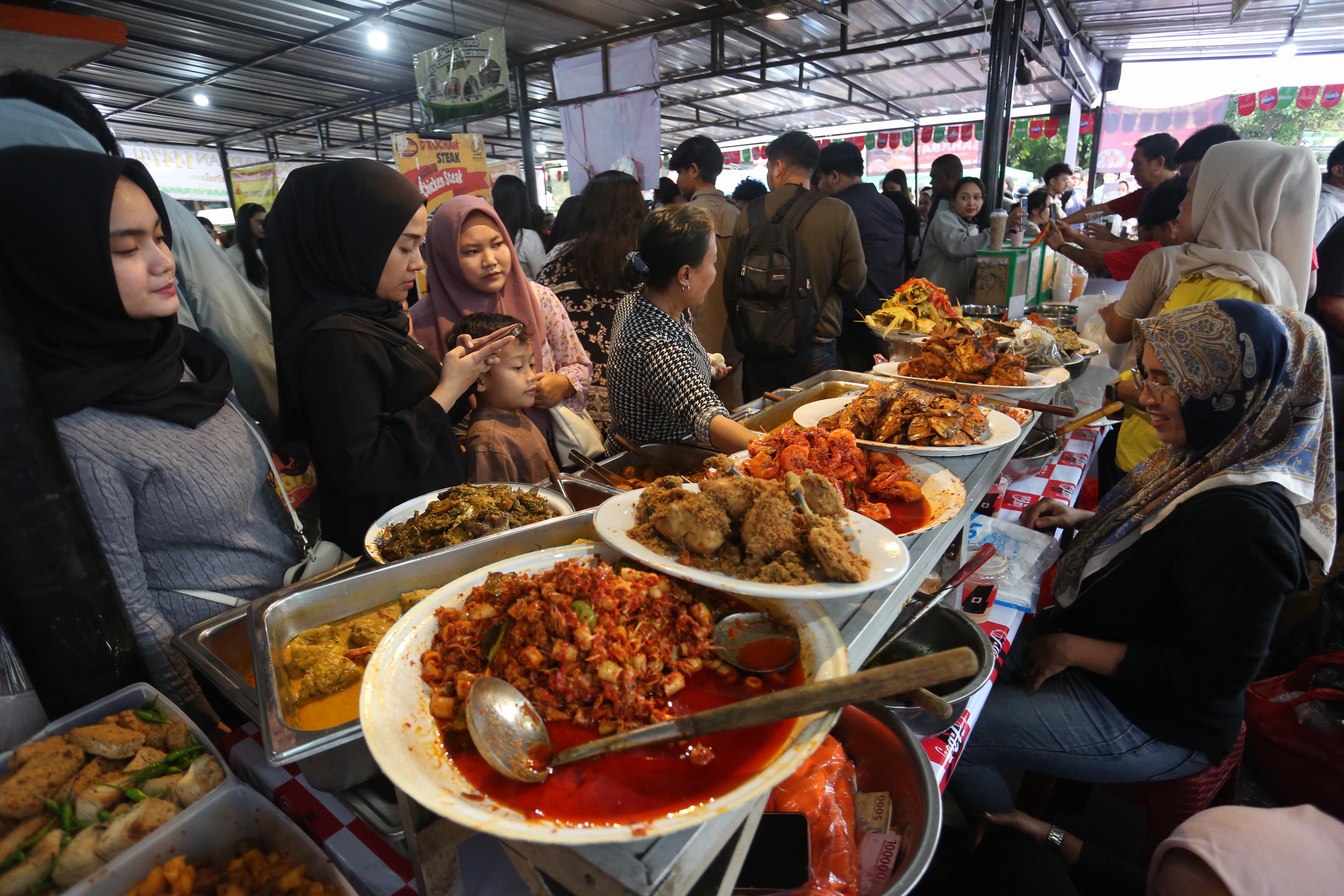 Warga melihat makanan yang dijual di Pasar Takjil Bendungan Hilir, Jakarta Pusat, Kamis (19/2/2026). Bazar yang rutin digelar setiap bulan Ramadan ini menjadi salah satu lokasi favorit bagi warga untuk berburu takjil mulai dari aneka gorengan, kue tradisional hingga makanan berat seperti ayam goreng dan ikan bakar.