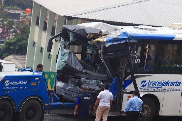 Sejumlah petugas berada di dekat bus TransJakarta yang mengalami kecelakaan tabrakan antar sesama bus TransJakarta di jalur layang atau jalur langit Koridor 13, Cipulir, Jakarta, Senin (23/2/2026). Tabrakan tersebut diduga karena kedua sopir mengantuk dan sebanyak 18 penumpang mengalami luka ringan dalam peristiwa itu.