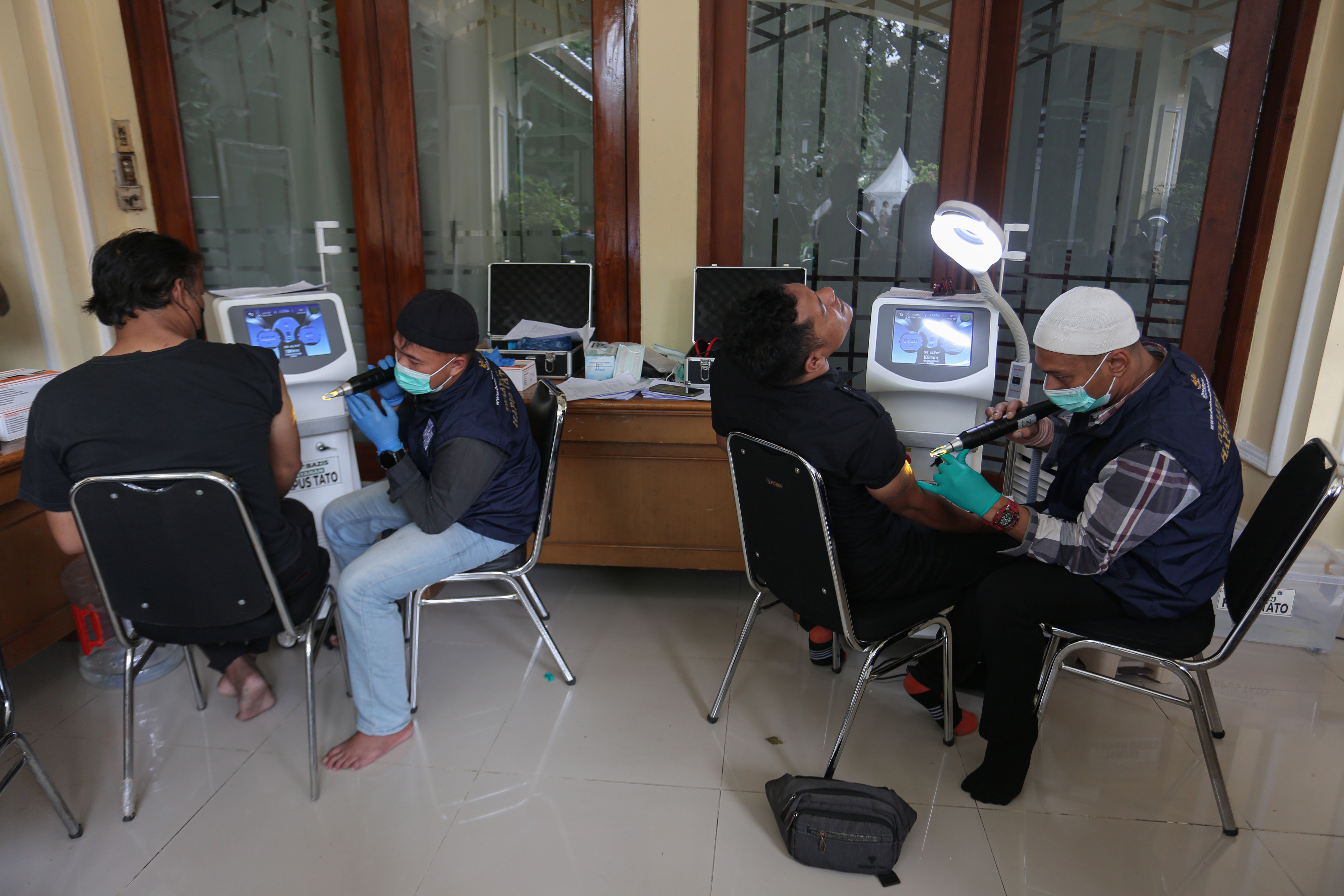 Petugas menghapus tato warga menggunakan laser di Masjid Agung Sunda Kelapa, Menteng, Jakarta Pusat, Selasa (24/2/2026). Kegiatan yang digelar oleh Baznas/Bazis DKI Jakarta ini bertujuan memberikan kesempatan kepada masyarakat yang ingin berhijrah dan memperbaiki diri melalui penghapusan tato secara gratis, aman dan sesuai prosedur medis.