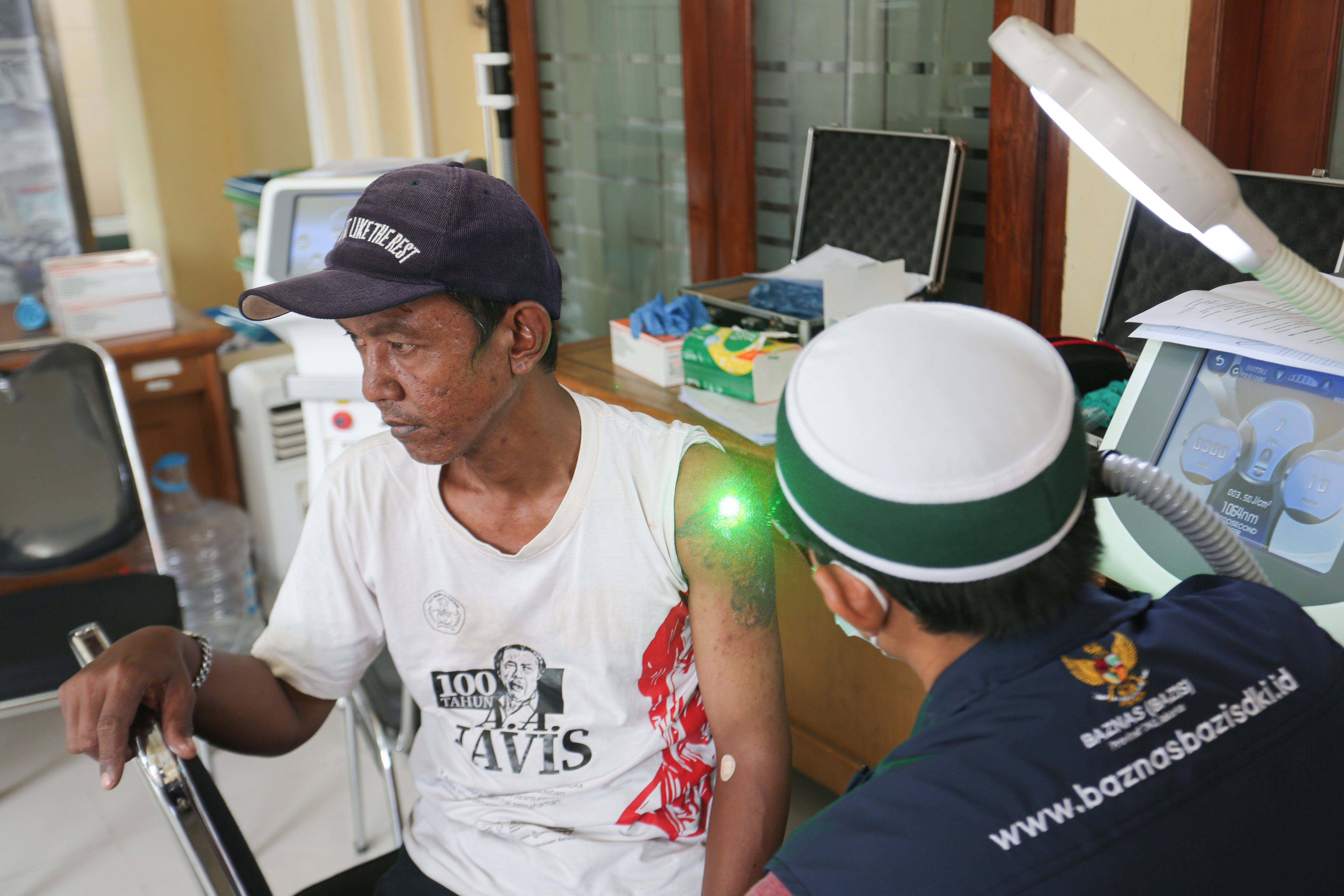 Petugas menghapus tato warga menggunakan laser di Masjid Agung Sunda Kelapa, Menteng, Jakarta Pusat, Selasa (24/2/2026). Kegiatan yang digelar oleh Baznas/Bazis DKI Jakarta ini bertujuan memberikan kesempatan kepada masyarakat yang ingin berhijrah dan memperbaiki diri melalui penghapusan tato secara gratis, aman dan sesuai prosedur medis.