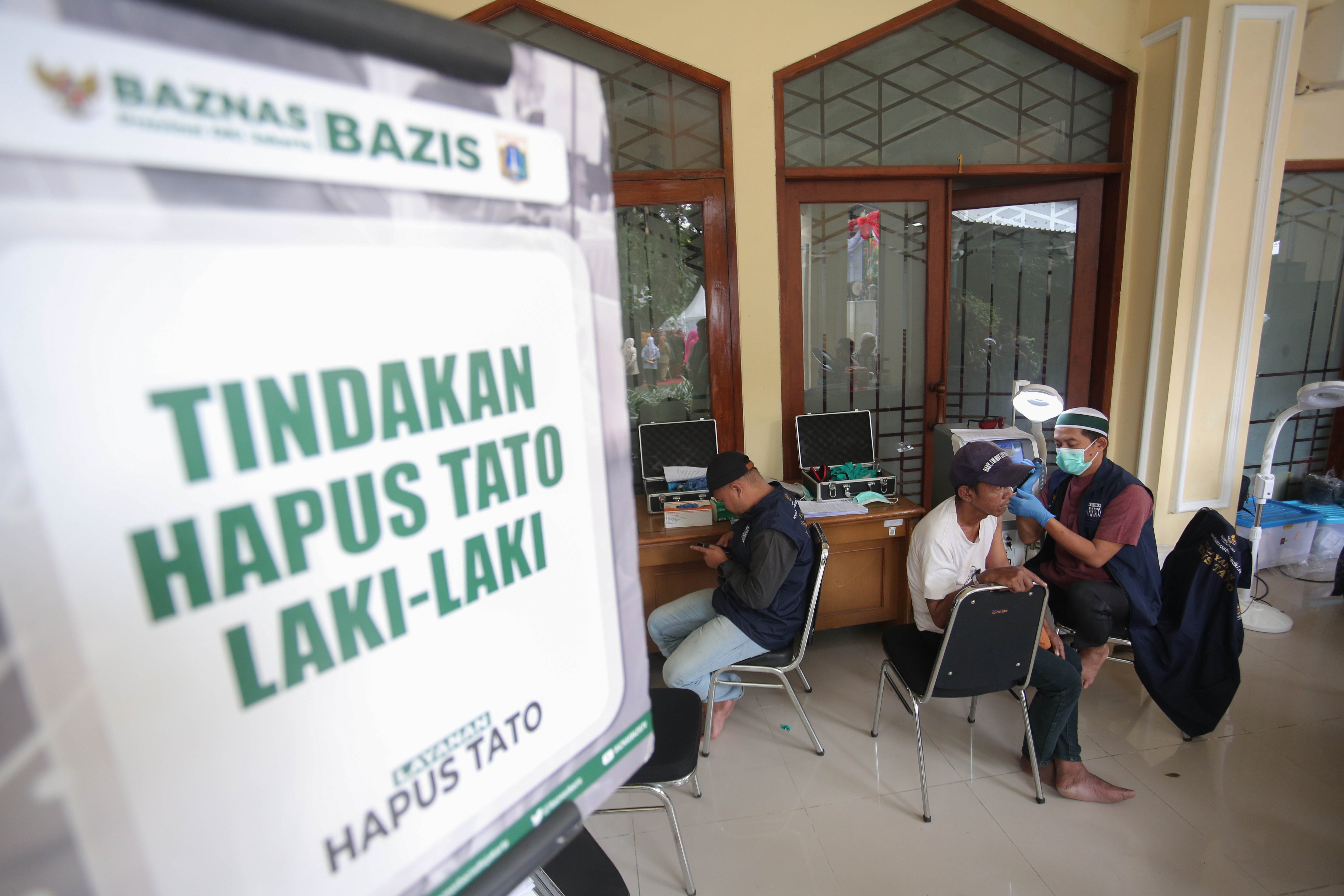 Petugas menghapus tato warga menggunakan laser di Masjid Agung Sunda Kelapa, Menteng, Jakarta Pusat, Selasa (24/2/2026). Kegiatan yang digelar oleh Baznas/Bazis DKI Jakarta ini bertujuan memberikan kesempatan kepada masyarakat yang ingin berhijrah dan memperbaiki diri melalui penghapusan tato secara gratis, aman dan sesuai prosedur medis.