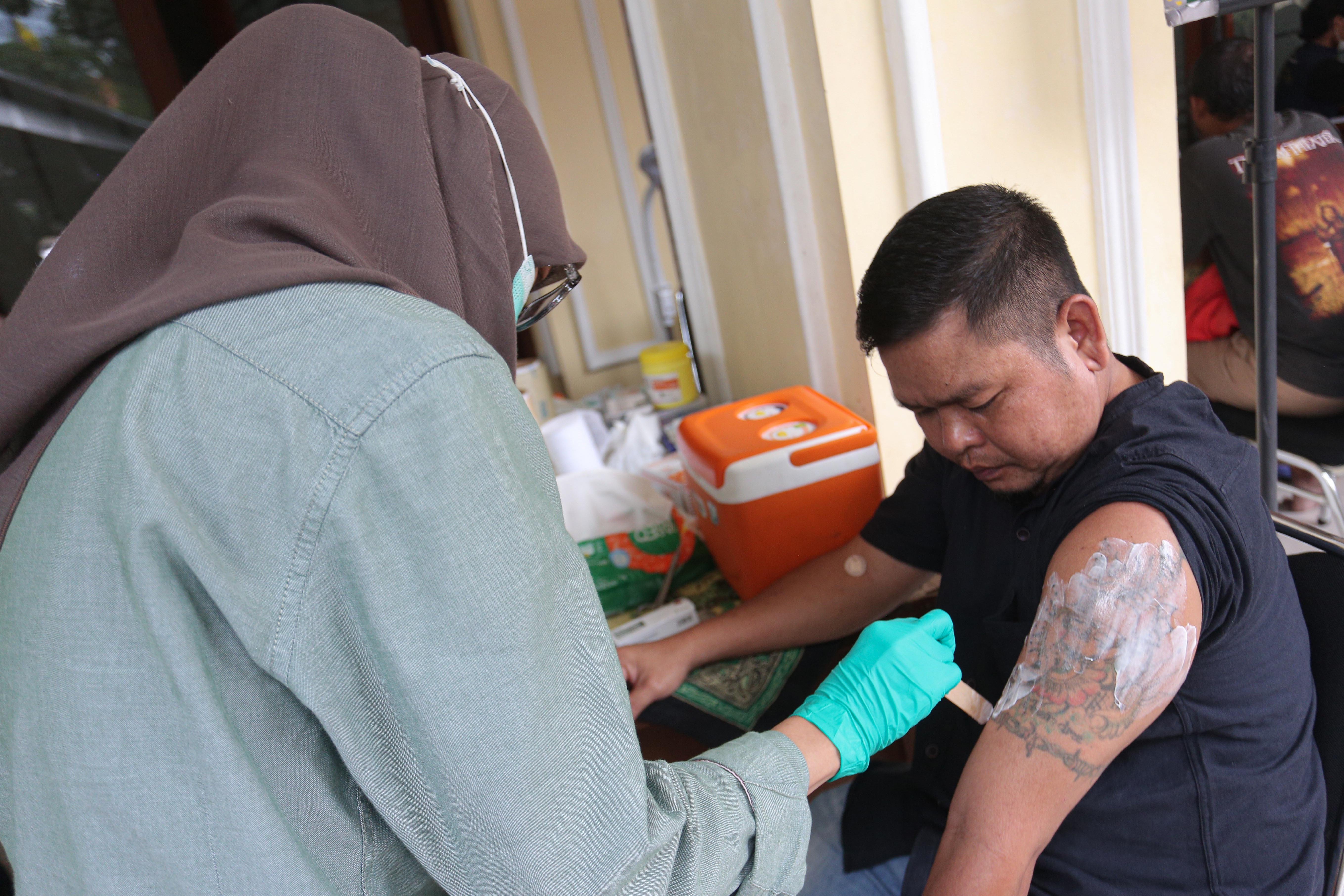 Petugas memberikan krim pereda nyeri kepada warga yang mengikuti layanan hapus tato gratis di Masjid Agung Sunda Kelapa, Menteng, Jakarta Pusat, Selasa (24/2/2026). Kegiatan yang digelar oleh Baznas/Bazis DKI Jakarta ini bertujuan memberikan kesempatan kepada masyarakat yang ingin berhijrah dan memperbaiki diri melalui penghapusan tato secara gratis, aman dan sesuai prosedur medis.