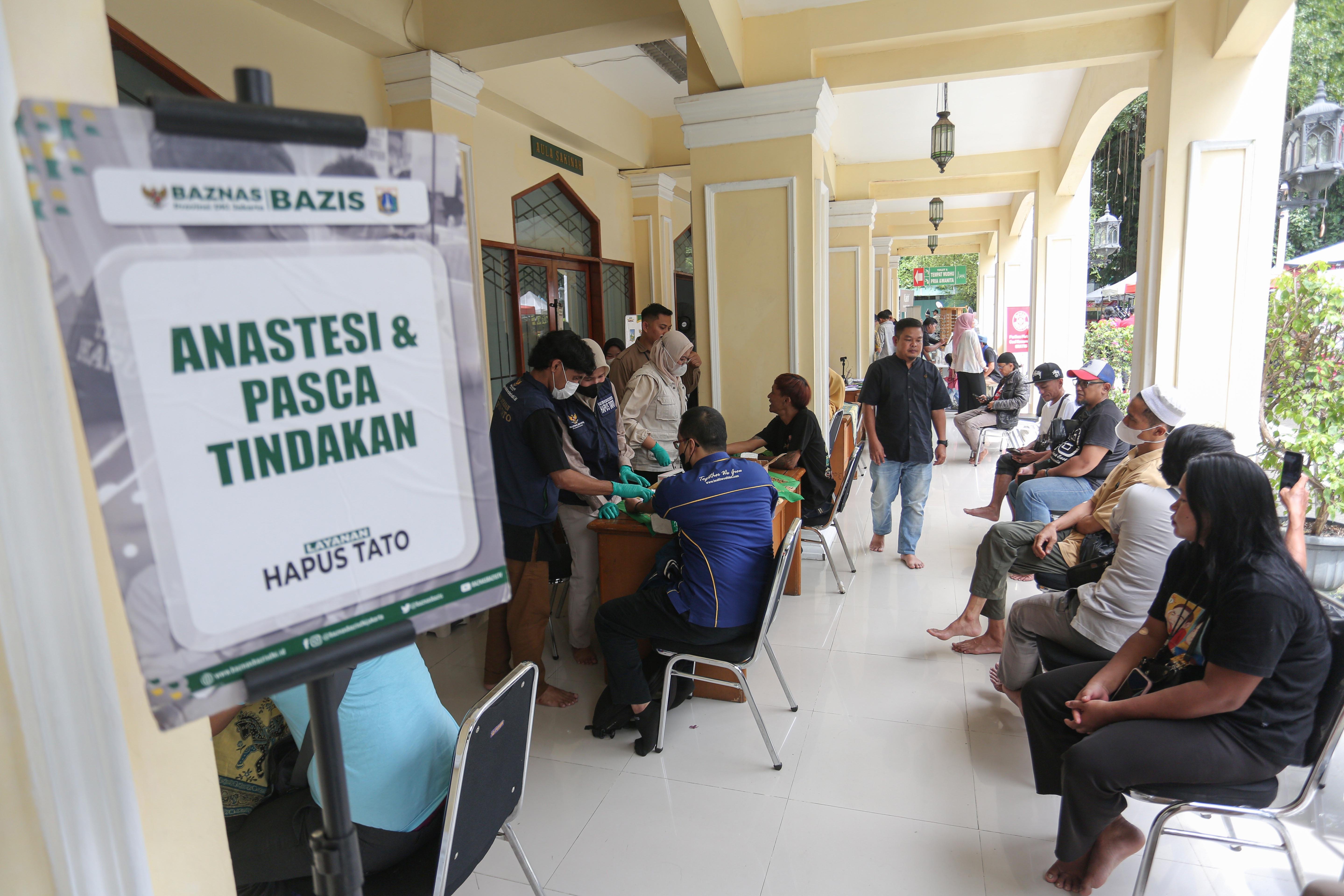 Warga mengantre untuk mengikuti layanan hapus tato gratis di Masjid Agung Sunda Kelapa, Menteng, Jakarta Pusat, Selasa (24/2/2026). Kegiatan yang digelar oleh Baznas/Bazis DKI Jakarta ini bertujuan memberikan kesempatan kepada masyarakat yang ingin berhijrah dan memperbaiki diri melalui penghapusan tato secara gratis, aman dan sesuai prosedur medis.