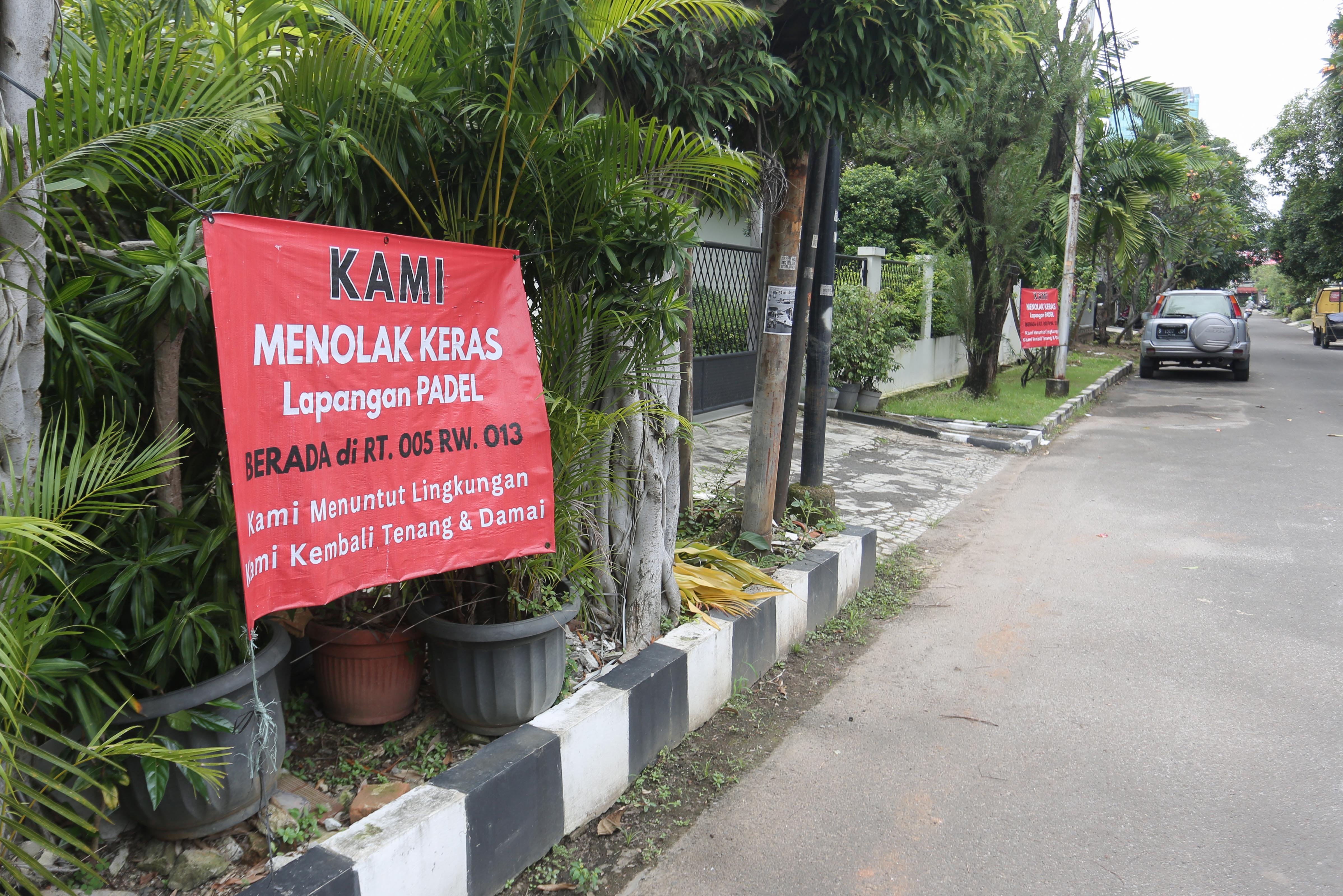 Spanduk penolakan lapangan padel di kawasan perumahan, Jalan Pulomas Barat II, Kayu Putih, Pulogadung, Jakarta Timur, Kamis (26/2/2026). Berdasarkan penuturan warga aksi pemasangan spanduk tersebut sebagai bentuk protes terhadap aktivitas olahraga di lapangan padel yang kerap menimbulkan suara bising dan mengganggu ketenangan warga.