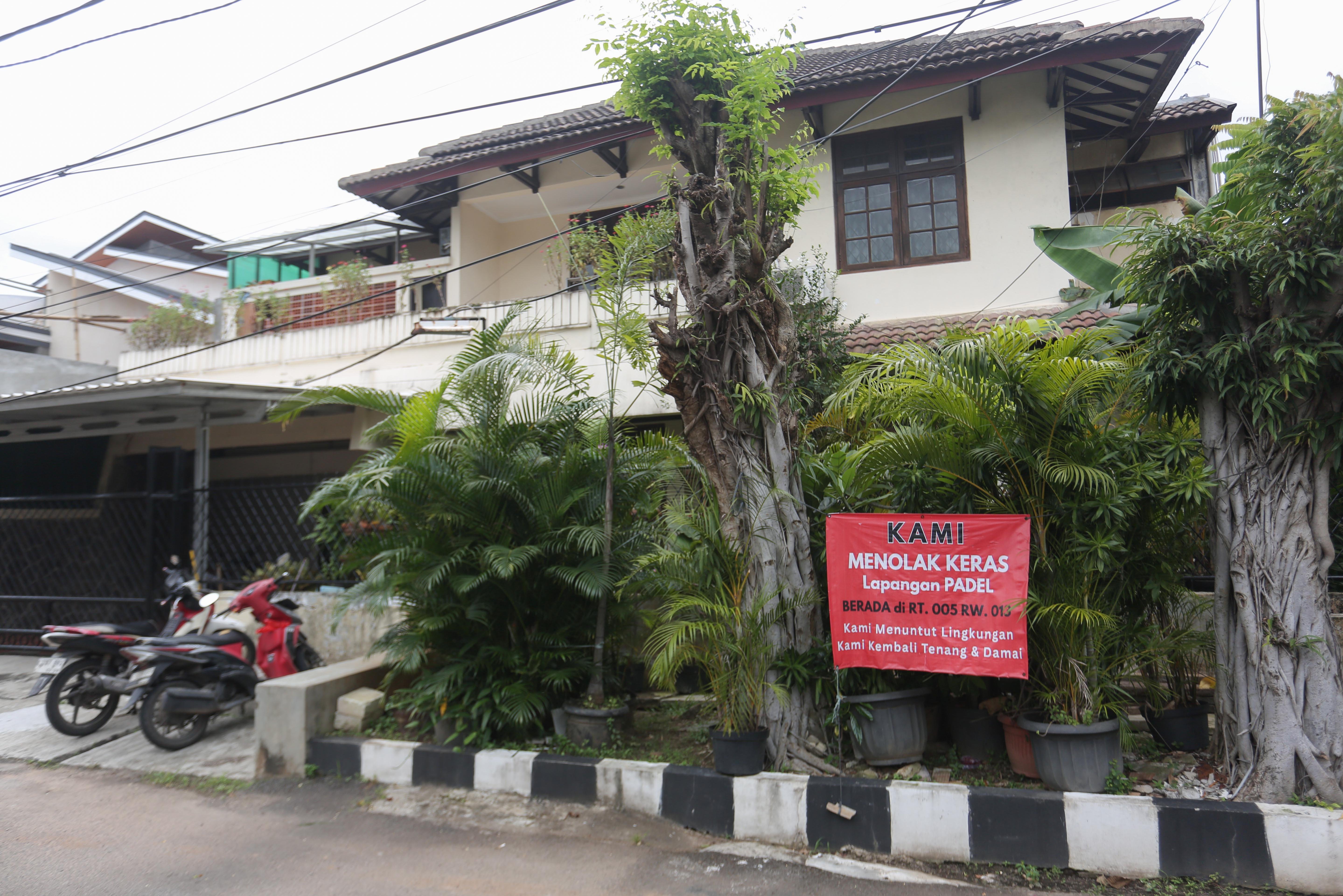 Spanduk penolakan lapangan padel di kawasan perumahan, Jalan Pulomas Barat II, Kayu Putih, Pulogadung, Jakarta Timur, Kamis (26/2/2026). Berdasarkan penuturan warga aksi pemasangan spanduk tersebut sebagai bentuk protes terhadap aktivitas olahraga di lapangan padel yang kerap menimbulkan suara bising dan mengganggu ketenangan warga.