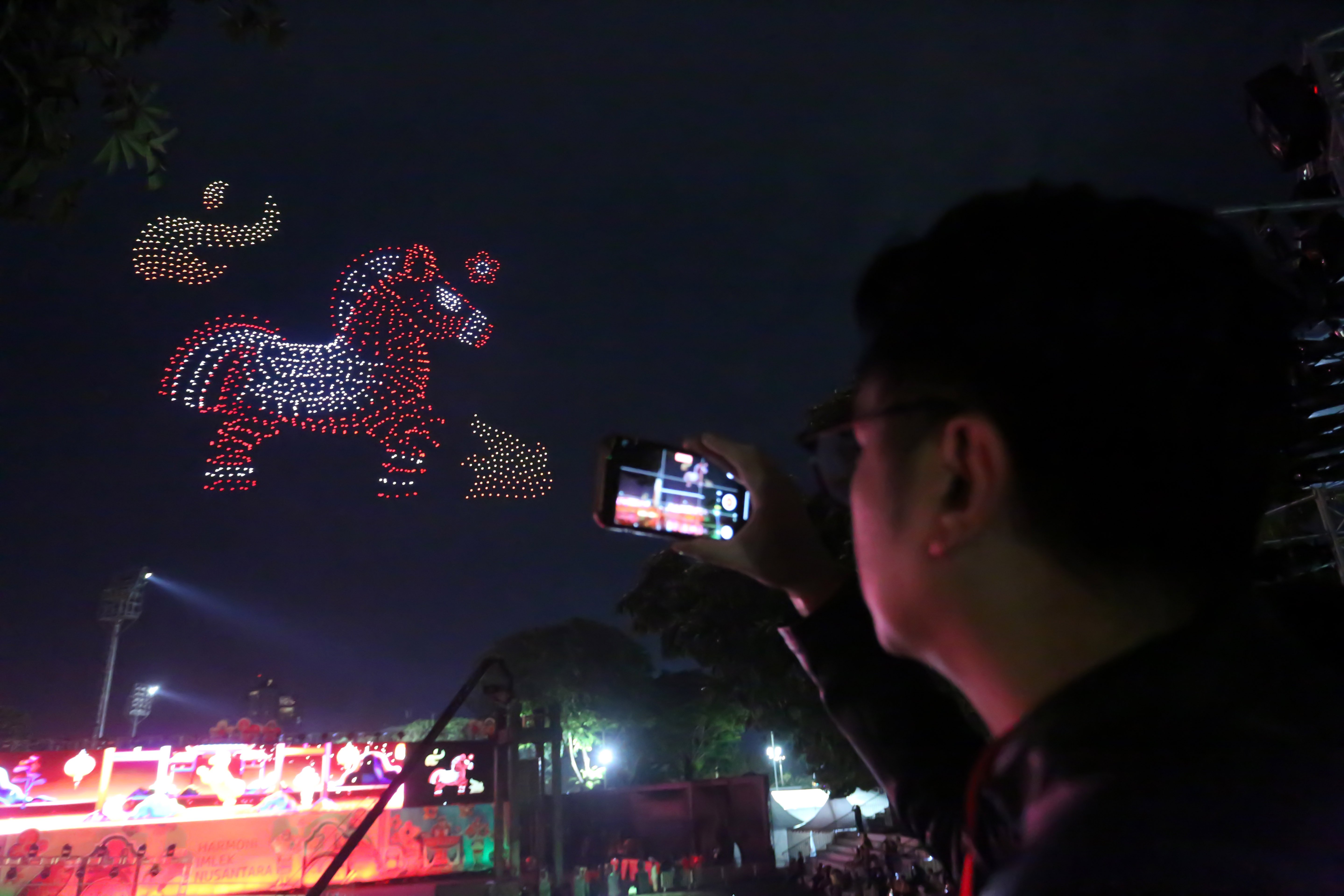 Warga merekam pertunjukan drone yang membentuk shio kuda api pada puncak perayaan Imlek Festival 2577 di Lapangan Banteng, Jakarta Pusat, Sabtu (28/2/2026). Bertajuk \