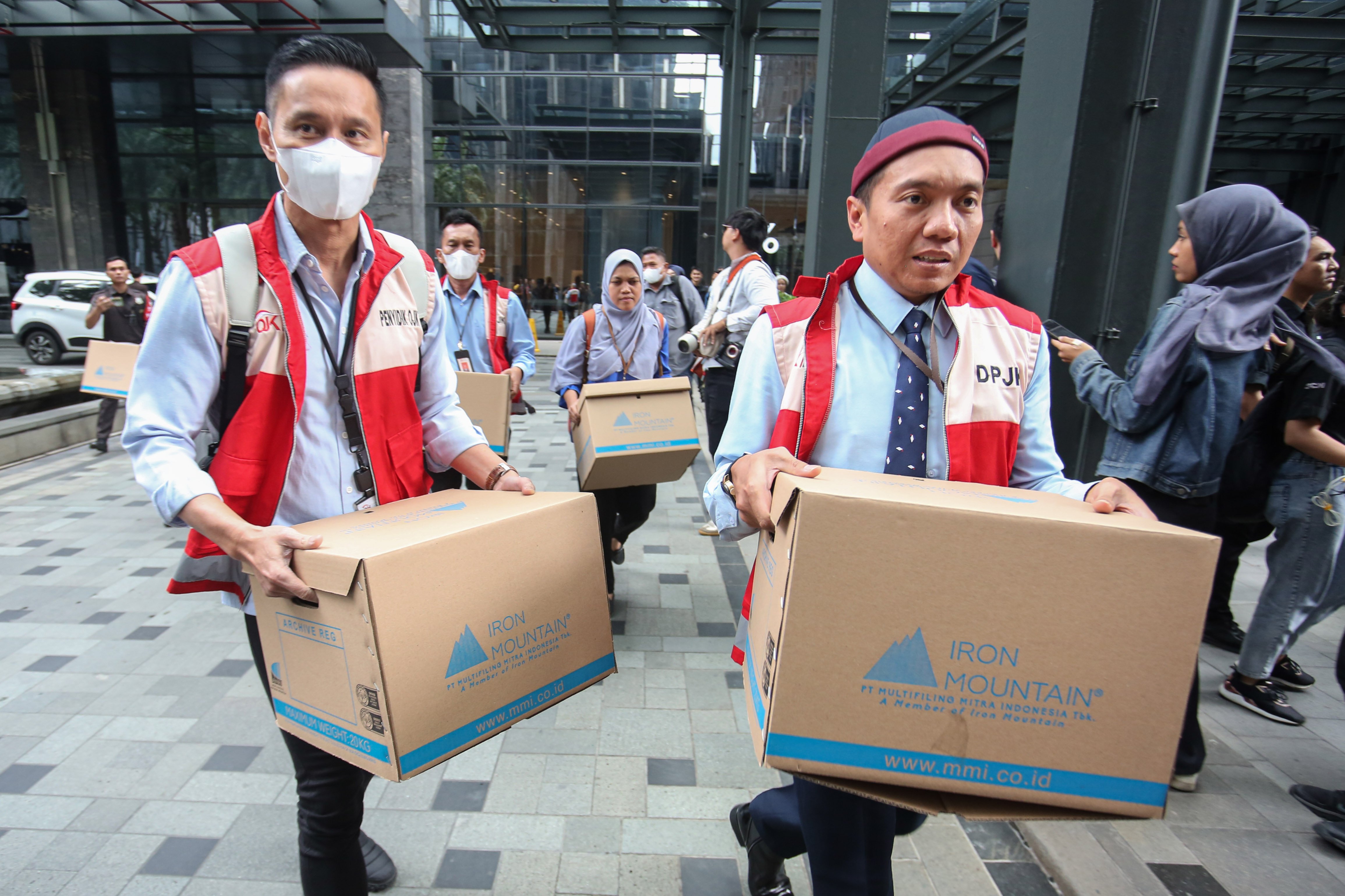 Tim penyidik Otoritas Jasa Keuangan (OJK) membawa barang bukti usai menggeledah kantor pusat perusahaan sekuritas di Treasury Tower, SCBD, Jakarta, Rabu (4/3/2026). OJK bersama Bareskrim Polri menggeledah kantor sekuritas berinisial PT MASI setelah menetapkan dua tersangka yakni AS dan M terkait transaksi semu saham dan perdagangan orang dalam atau insider trading.