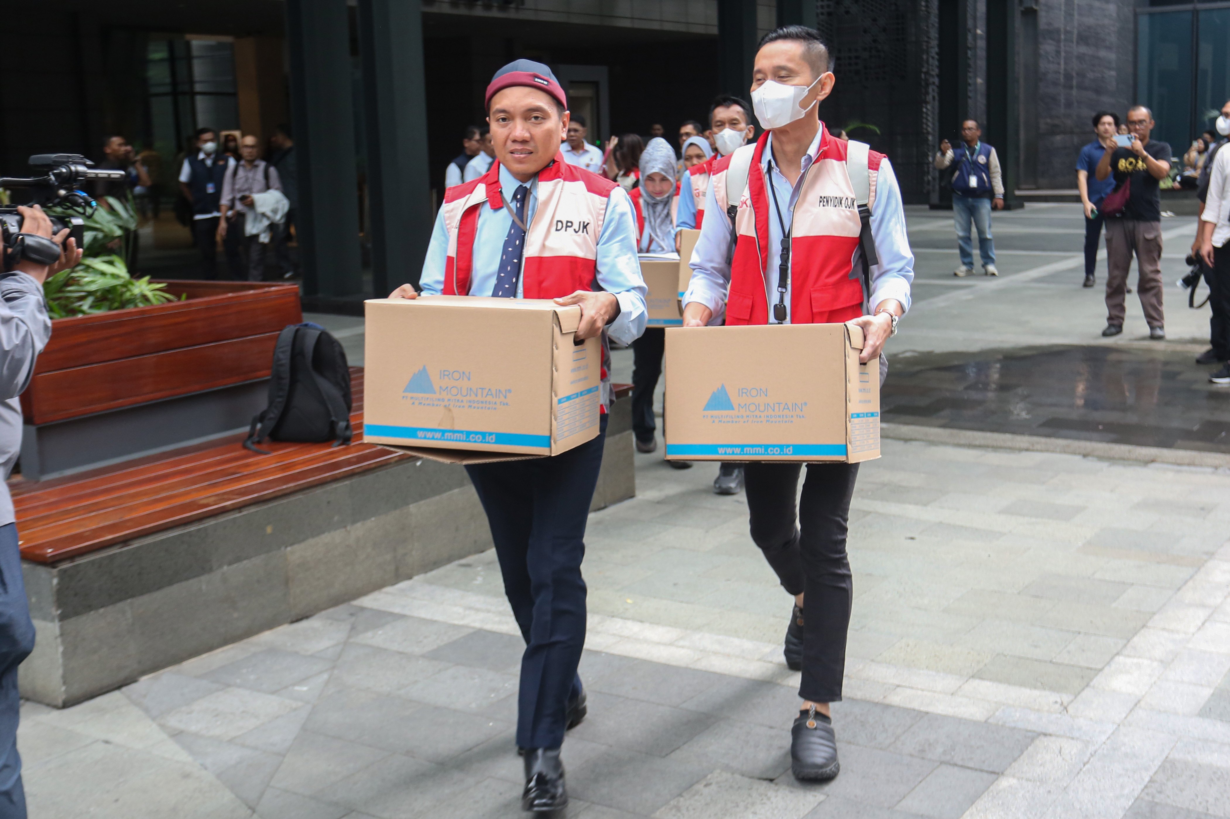 Tim penyidik Otoritas Jasa Keuangan (OJK) membawa barang bukti usai menggeledah kantor pusat perusahaan sekuritas di Treasury Tower, SCBD, Jakarta, Rabu (4/3/2026). OJK bersama Bareskrim Polri menggeledah kantor sekuritas berinisial PT MASI setelah menetapkan dua tersangka yakni AS dan M terkait transaksi semu saham dan perdagangan orang dalam atau insider trading.