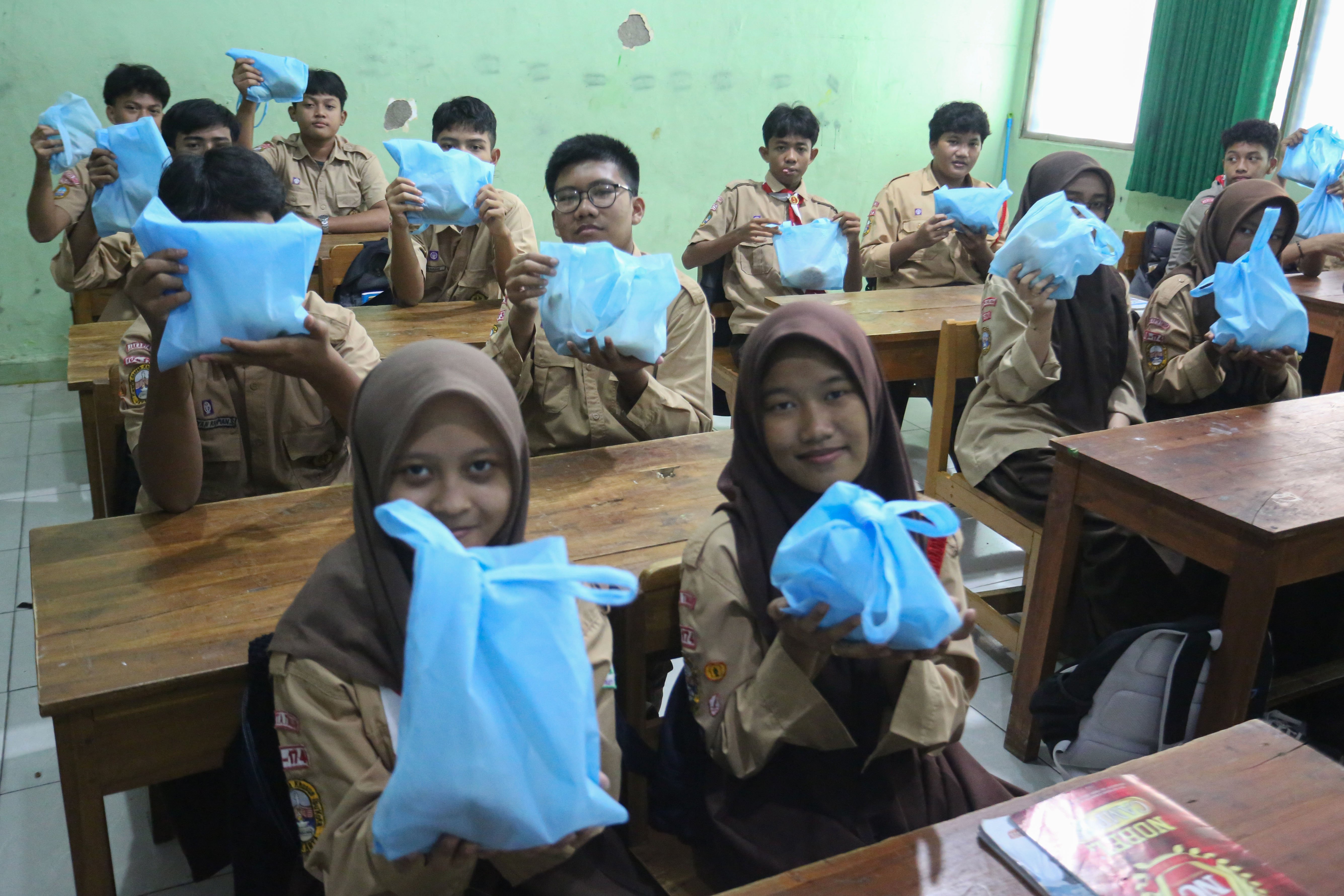Siswa menunjukkan paket Makan Bergizi Gratis (MBG) yang dibagikan di MTs As-Syafi\'iyah 04 Jakarta, Rabu (4/3/2026). Pada bulan Ramadan siswa mendapatkan MBG untuk dimakan di rumah saat berbuka puasa dengan menu yang terdiri dari roti, buah pisang, kurma dan telur puyuh rebus.