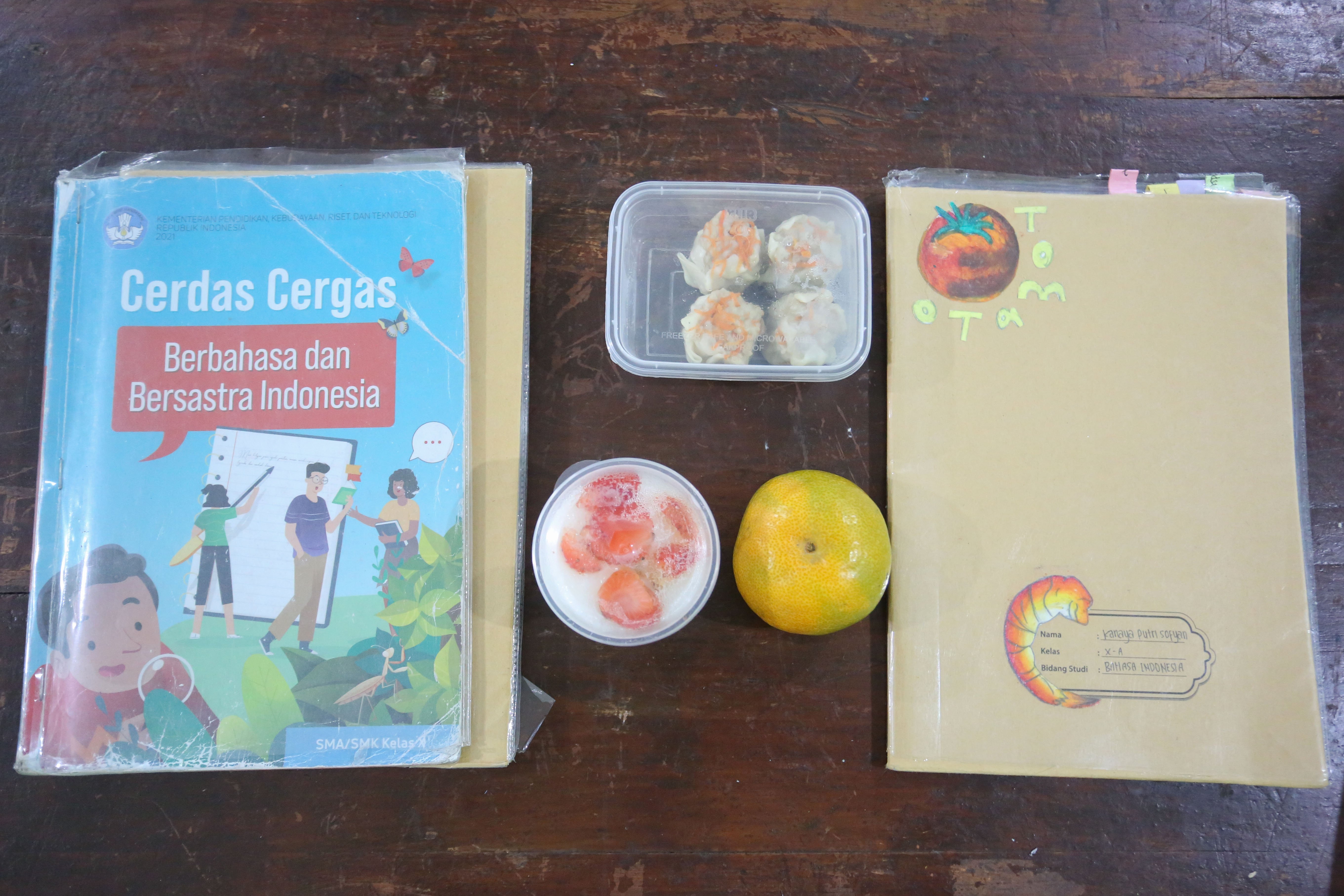 Makanan yang terdapat pada paket Makan Bergizi Gratis (MBG) yang dibagikan di SMA Negeri 64 Jakarta, Selasa (3/3/2026). Pada bulan Ramadan siswa mendapatkan MBG untuk dimakan di rumah saat berbuka puasa dengan menu yang terdiri dari dimsum ayam wortel, puding susu stroberi dan buah jeruk.
