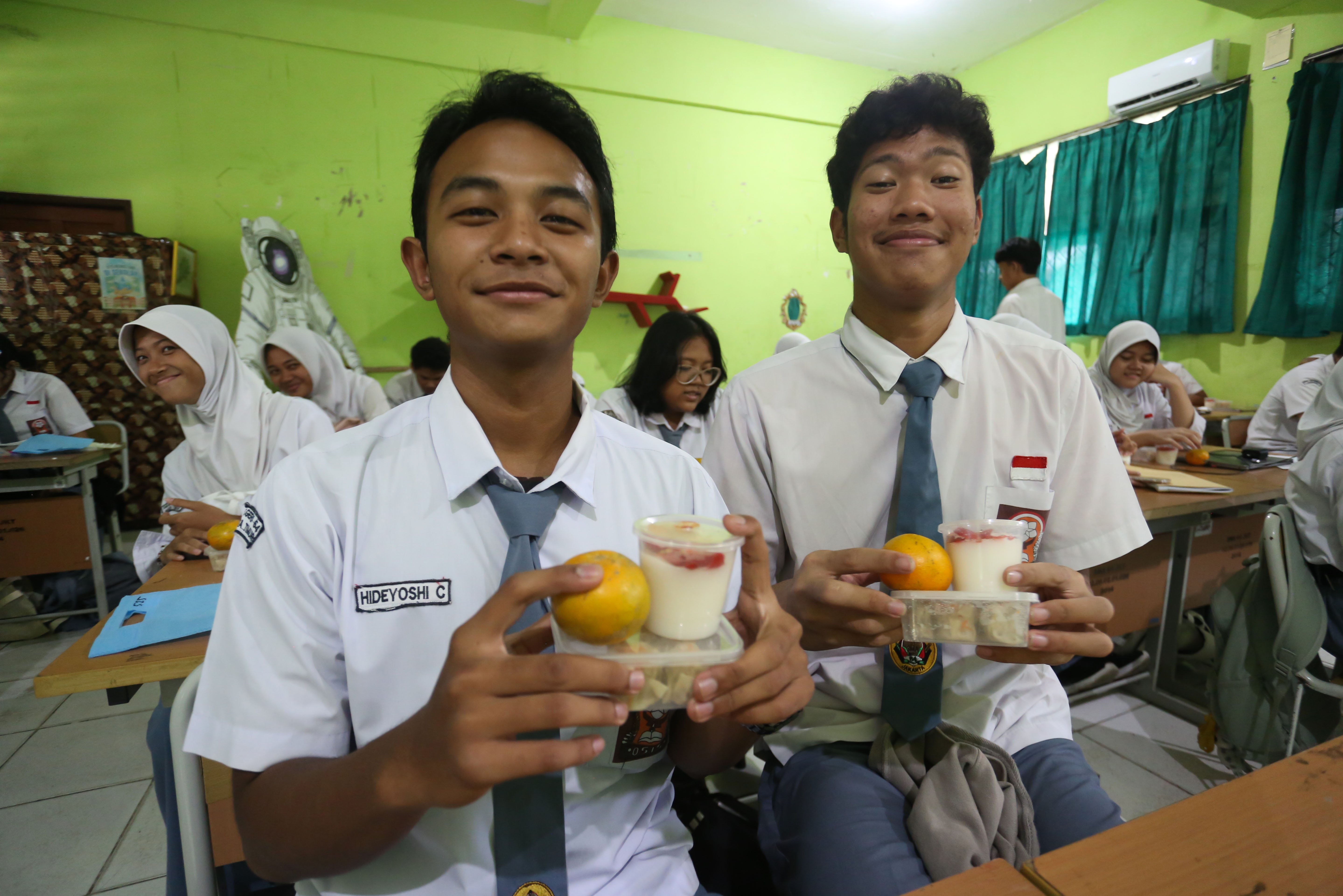 Siswa menunjukkan makanan pada paket Makan Bergizi Gratis (MBG) yang dibagikan di SMA Negeri 64 Jakarta, Selasa (3/3/2026). Pada bulan Ramadan siswa mendapatkan MBG untuk dimakan di rumah saat berbuka puasa dengan menu yang terdiri dari dimsum ayam wortel, puding susu stroberi dan buah jeruk.