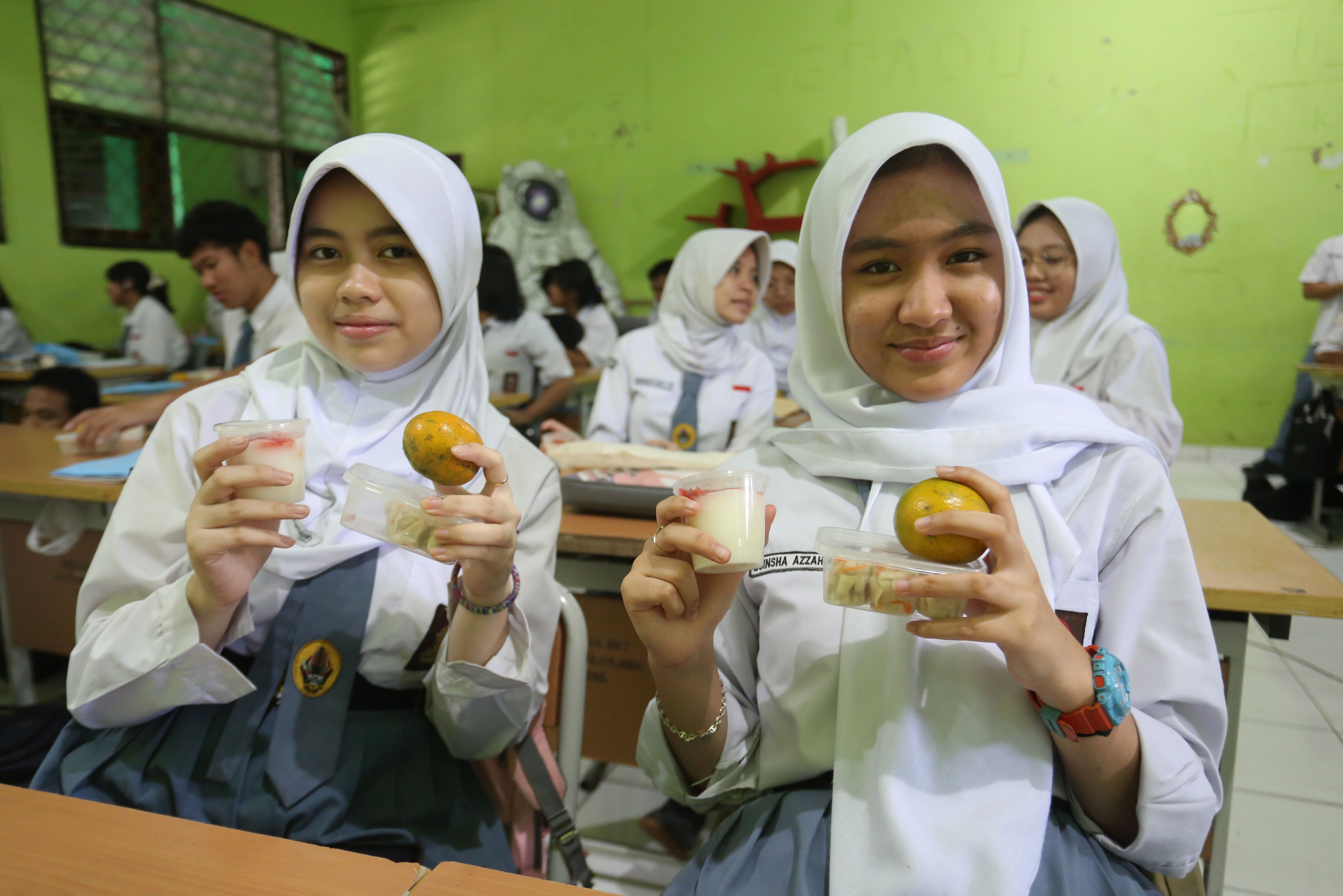 Siswi menunjukkan makanan pada paket Makan Bergizi Gratis (MBG) yang dibagikan di SMA Negeri 64 Jakarta, Selasa (3/3/2026). Pada bulan Ramadan siswa mendapatkan MBG untuk dimakan di rumah saat berbuka puasa dengan menu yang terdiri dari dimsum ayam wortel, puding susu stroberi dan buah jeruk.