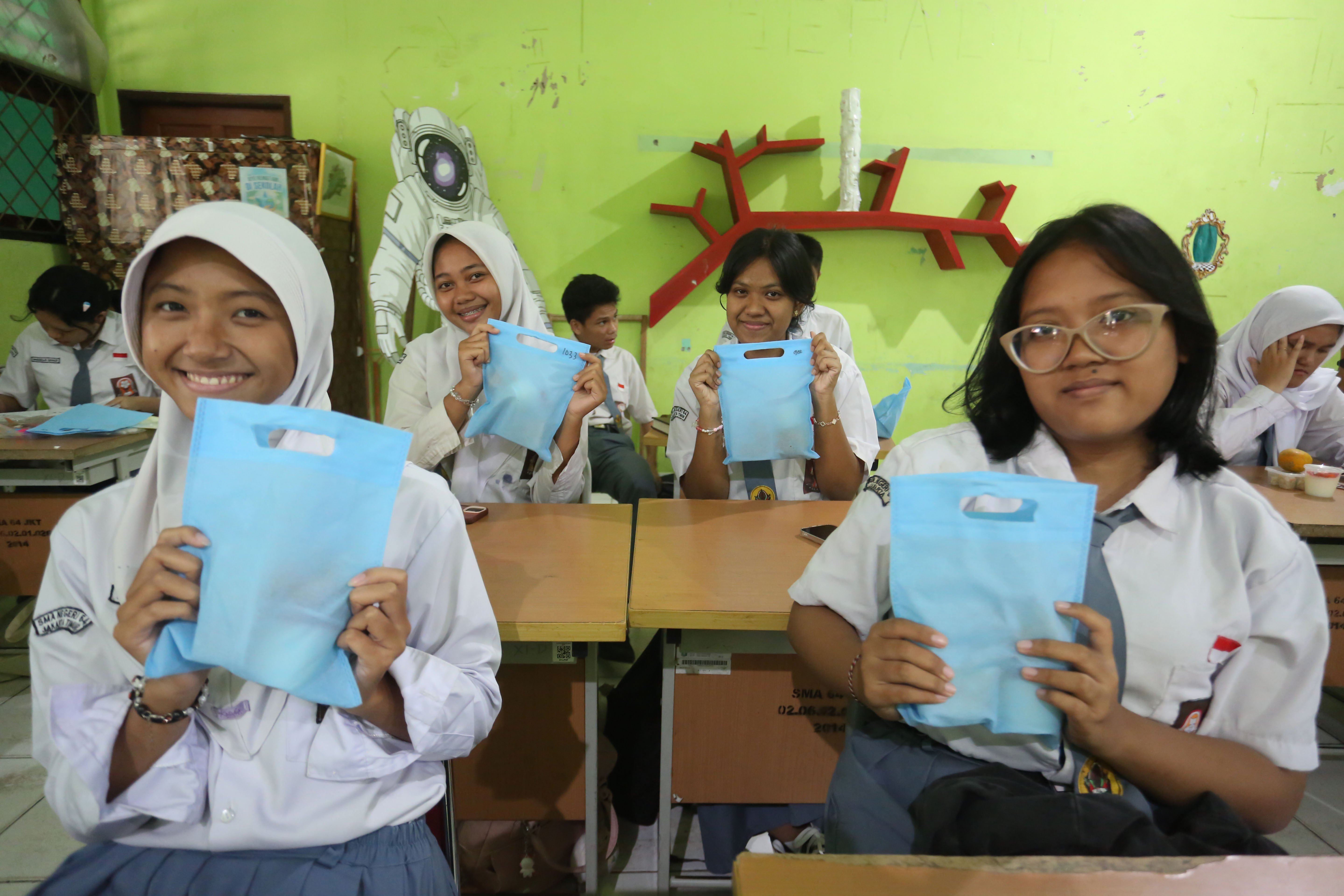Siswi menunjukkan paket Makan Bergizi Gratis (MBG) yang dibagikan di SMA Negeri 64 Jakarta, Selasa (3/3/2026). Pada bulan Ramadan siswa mendapatkan MBG untuk dimakan di rumah saat berbuka puasa dengan menu yang terdiri dari dimsum ayam wortel, puding susu stroberi dan buah jeruk.