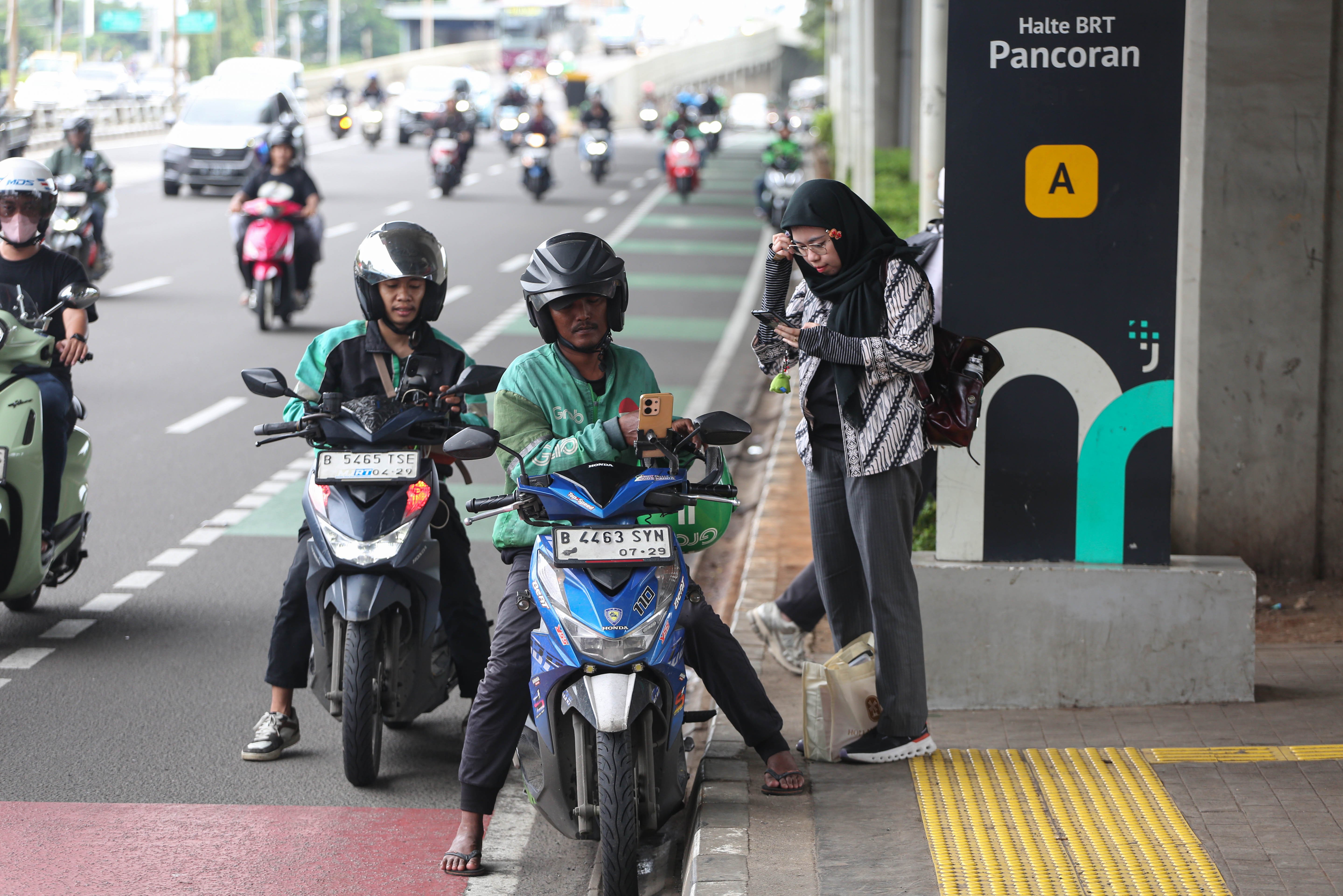 Pengemudi ojek online (ojol) menunggu pesanan di Jalan Gatot Subroto, Jakarta, Kamis (5/3/2026). Pemerintah menetapkan besaran Bonus Hari Raya atau BHR untuk mitra pengemudi taksi online dan ojol yakni 25% dari rata-rata pendapatan bersih selama 12 bulan terakhir.
